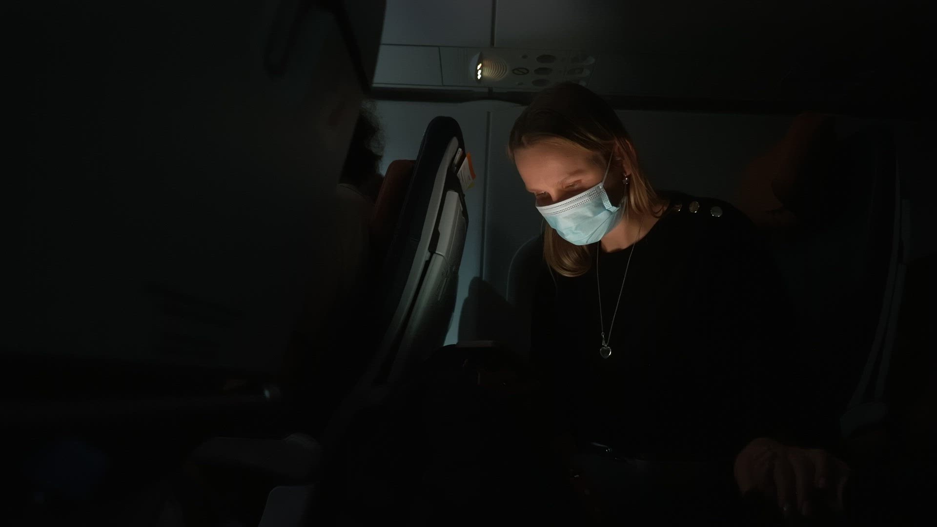 Woman plane passenger using phone at night