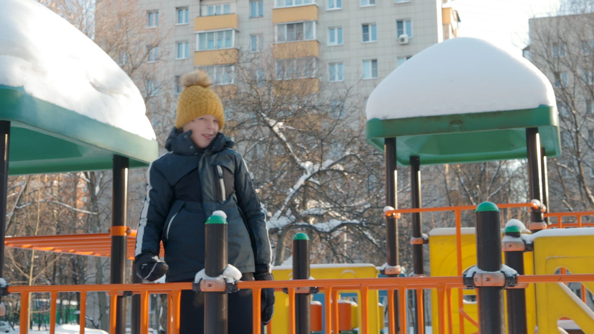 Happy and active boy the playground in winter