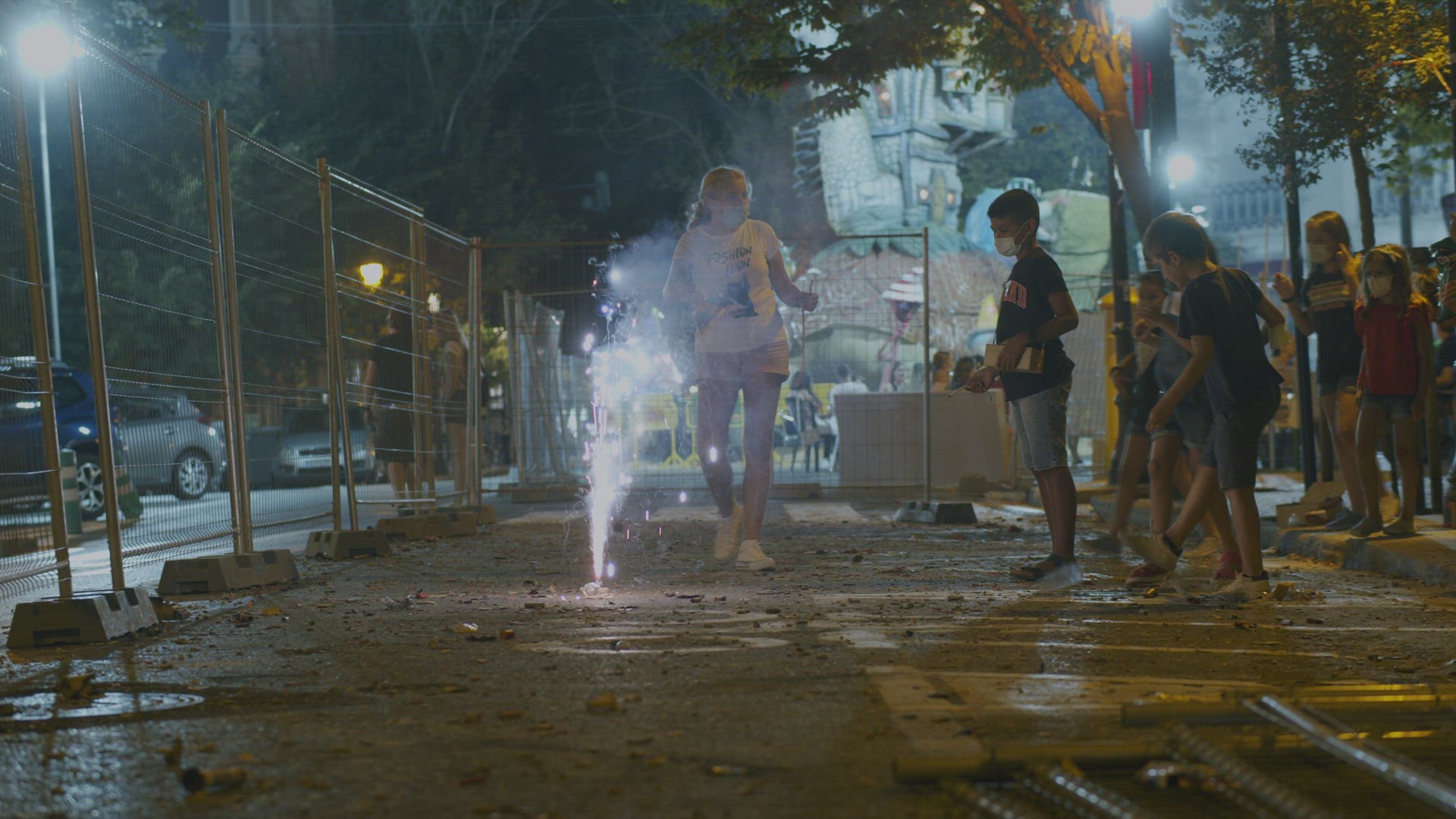 Children celebrating Fallas with fountain firework in night city