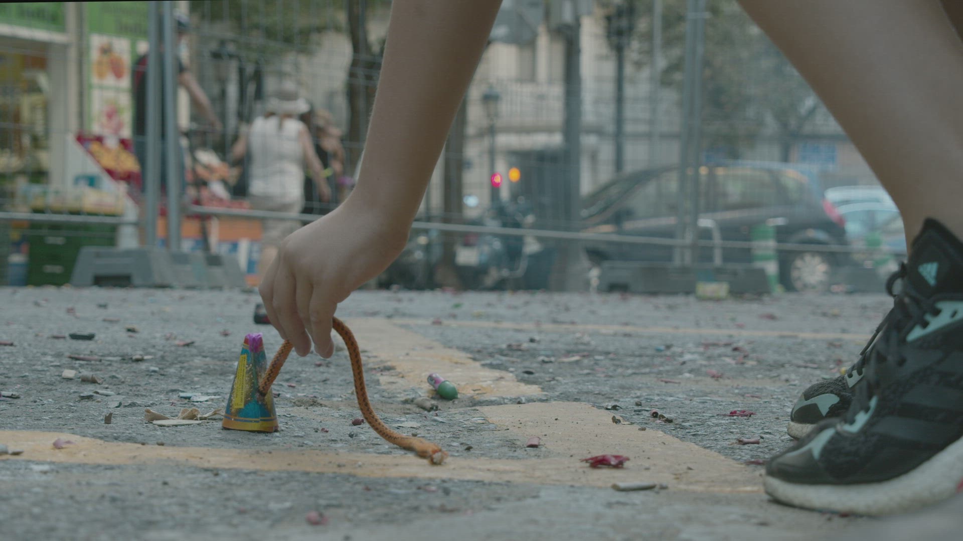 Kid lighting a fuse of a firecracker on Las Fallas