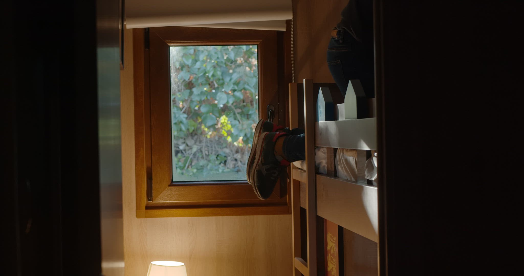 Boy coming down a ladder of double bunk bed