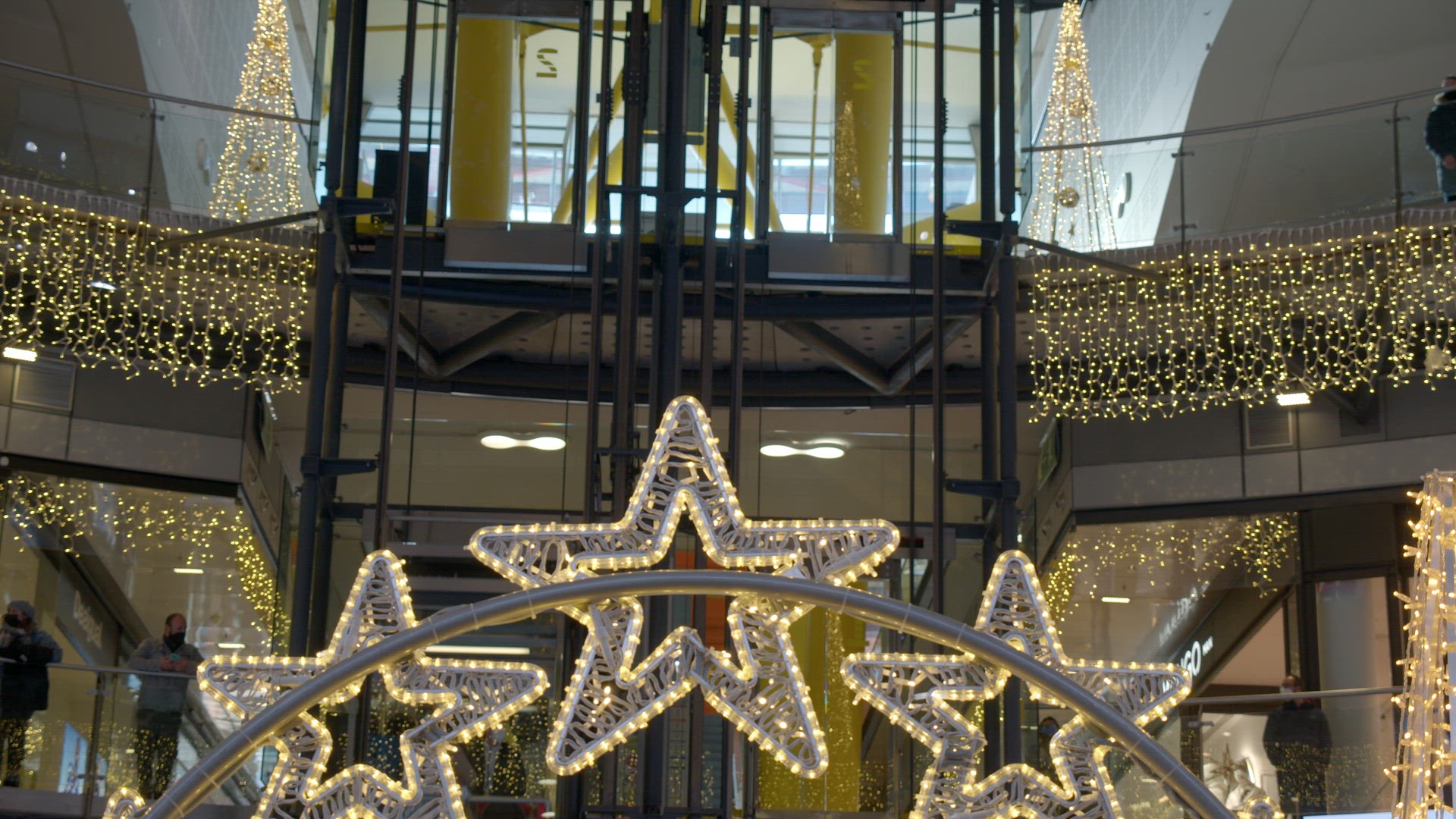 Customers in shopping centre with Christmas lights and decoration