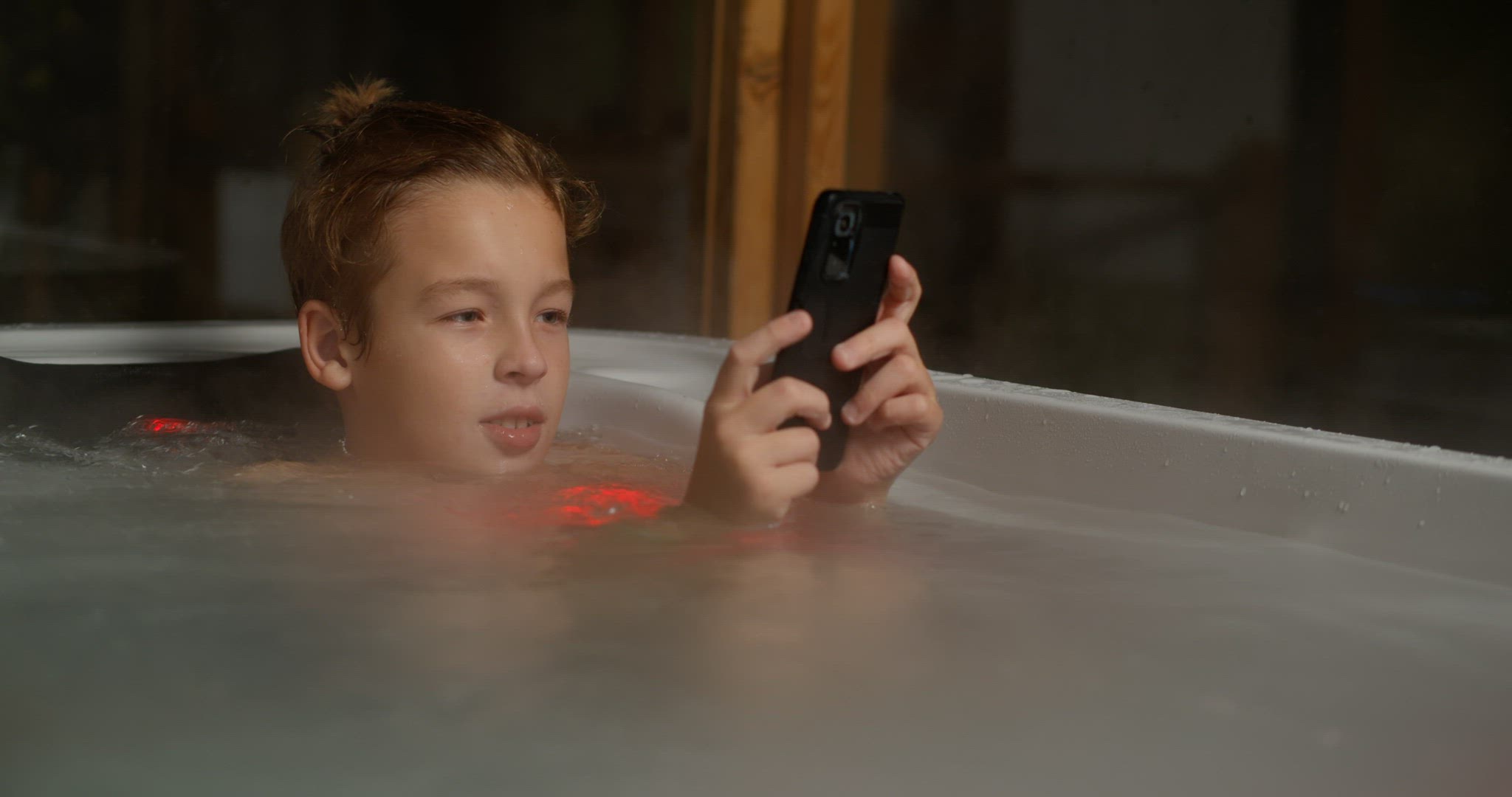 Boy in outdoor bathroom with mobile phone