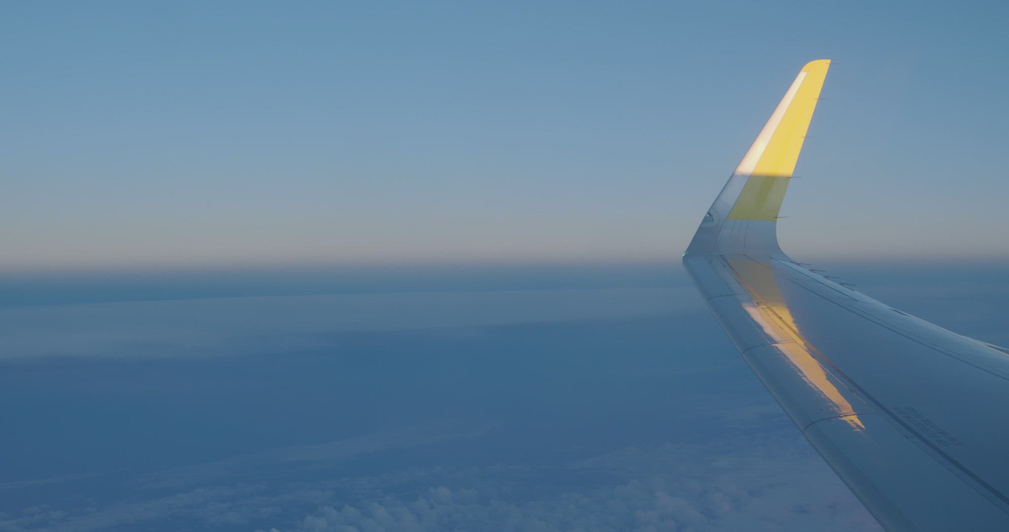 Wing of the plane with clouds