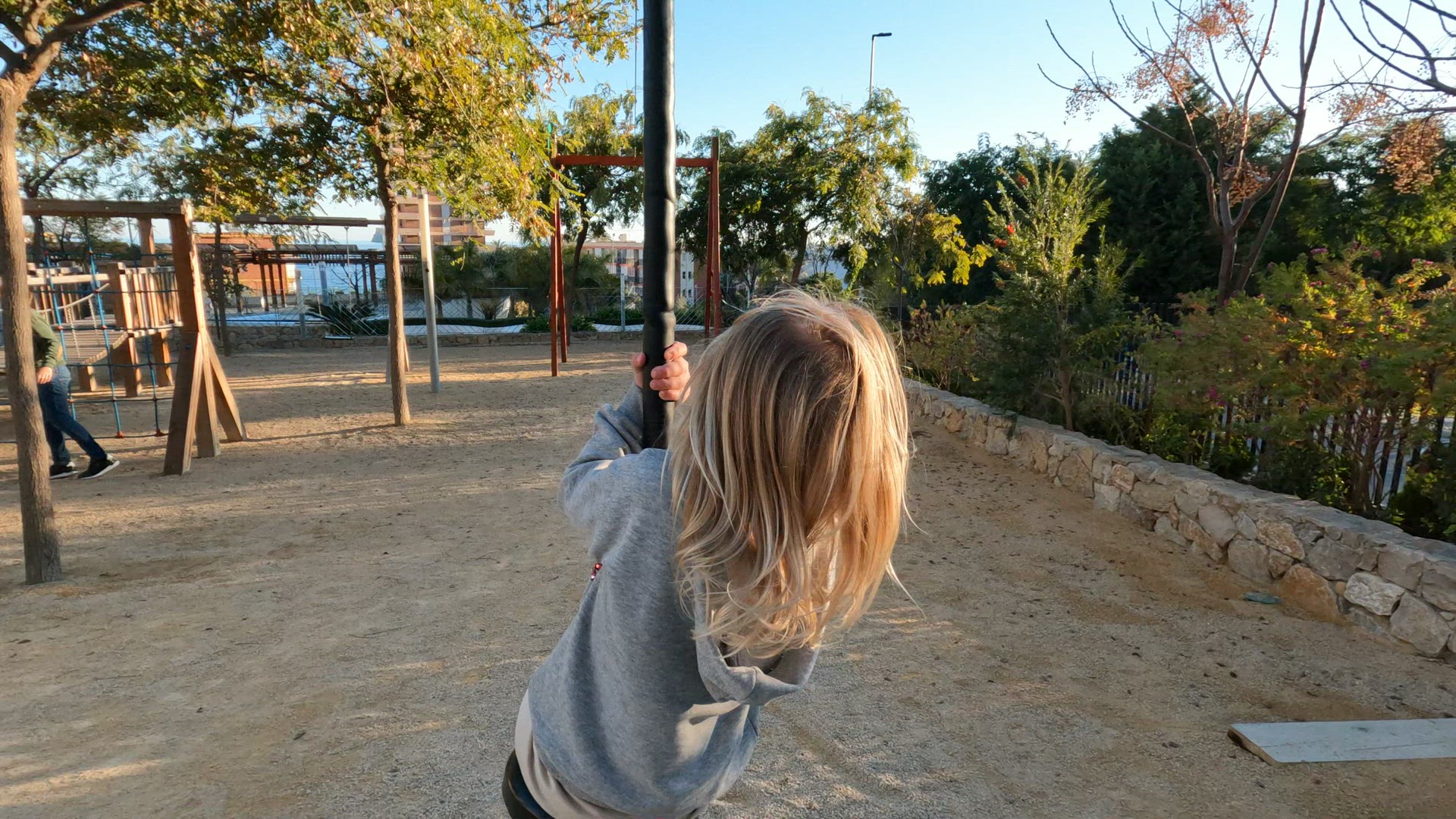 Kid enjoying exciting rope swing ride on the playground