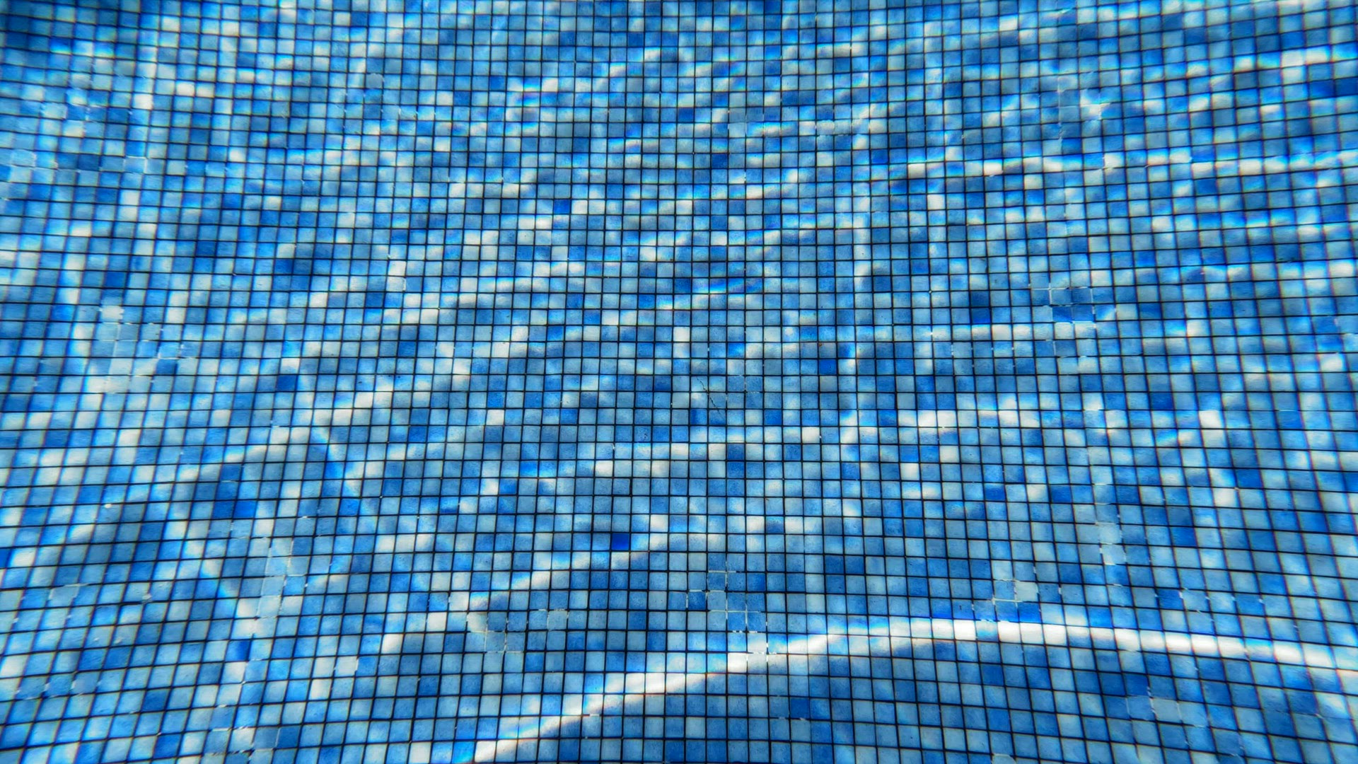 Pure water in the swimming pool with sun sparkles