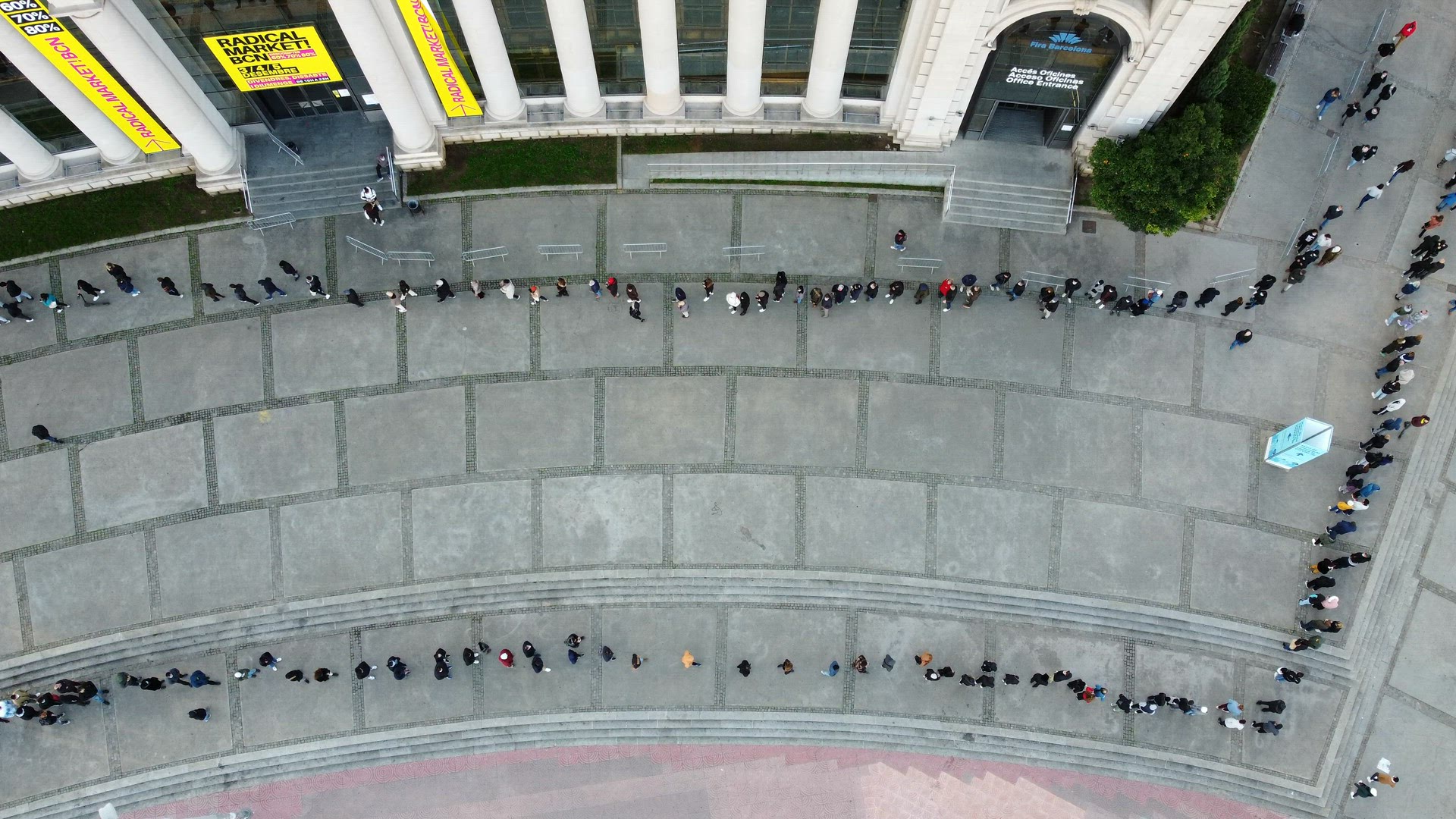 People waiting turn in long queue to Radical Market, aerial view
