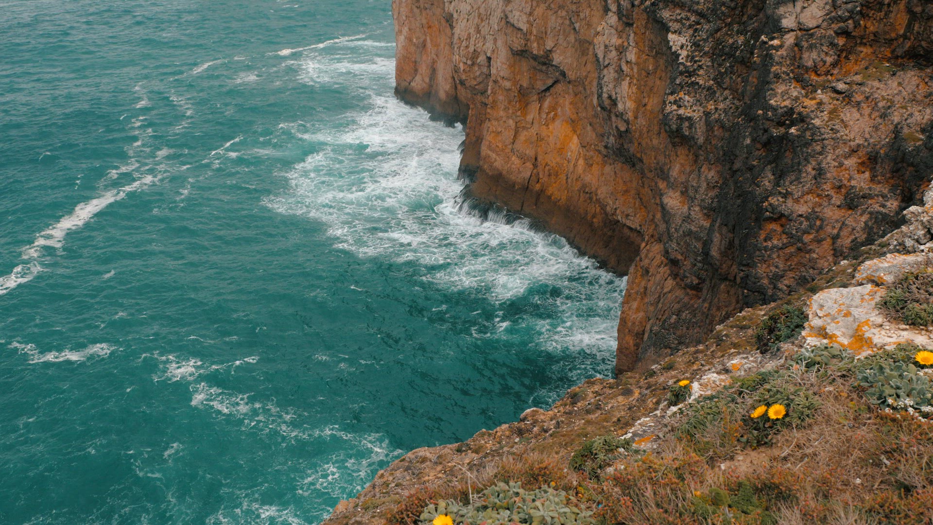 Azure ocean waves crashing rocks of Cape St. Vincent in Portugal