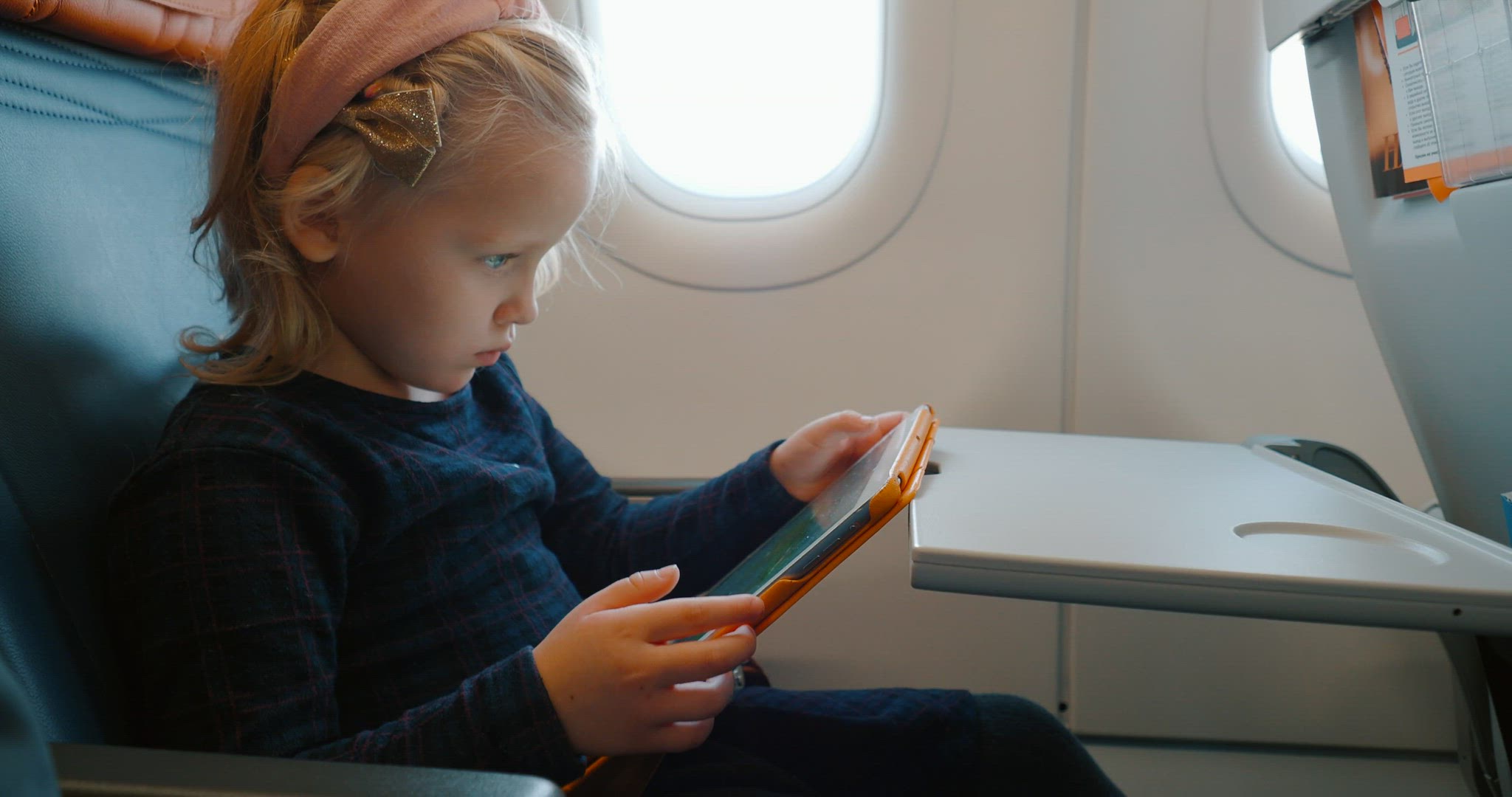 Child using digital tablet in the airplane