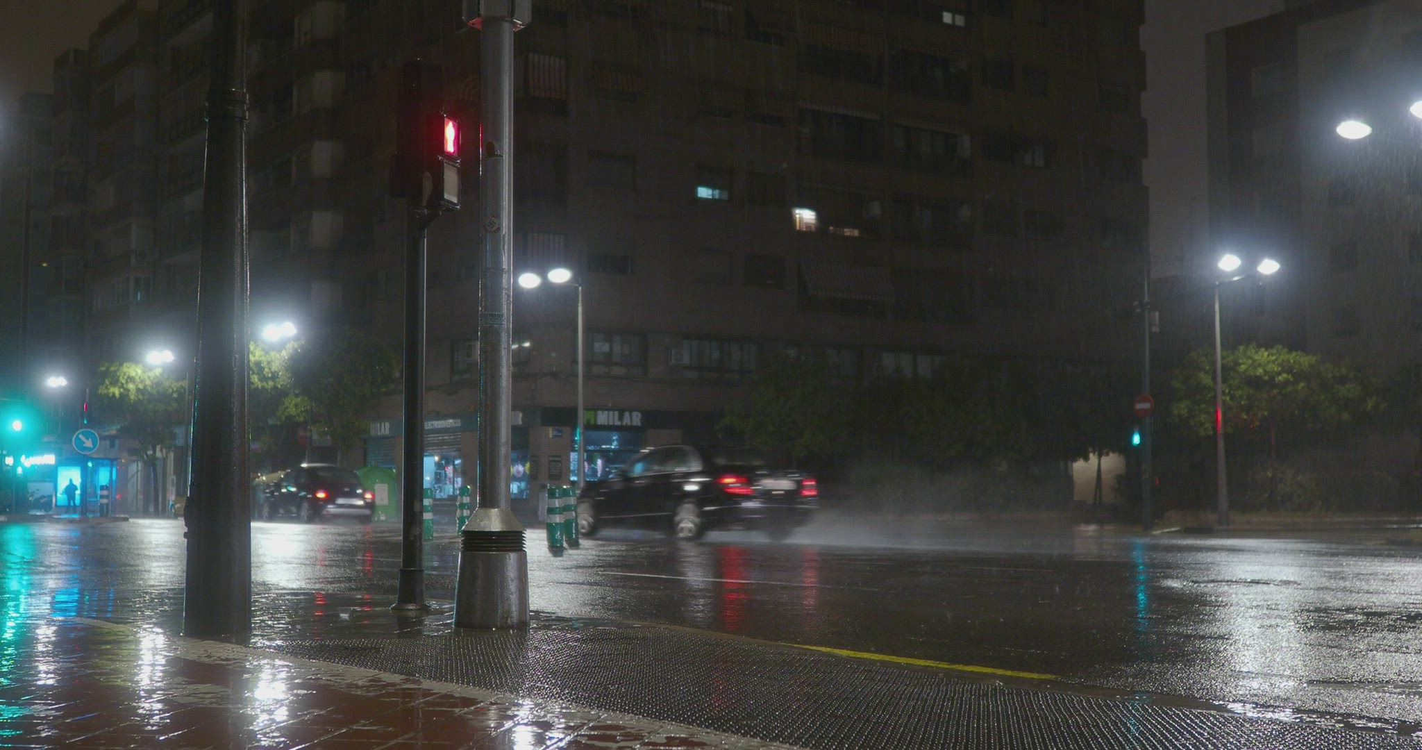 Scooter driver setting off under the rain in night city