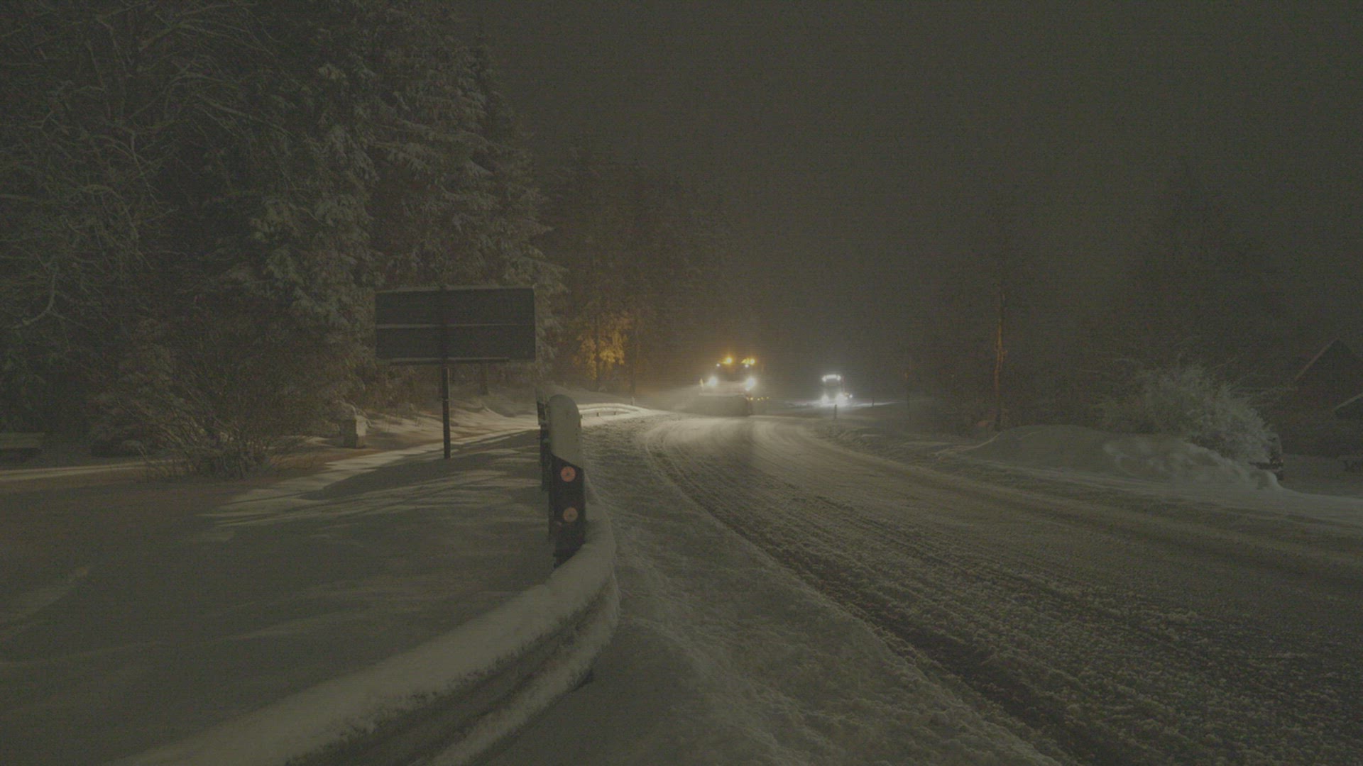 Snow plow clearing a road at nigh, Winterberg, Germany