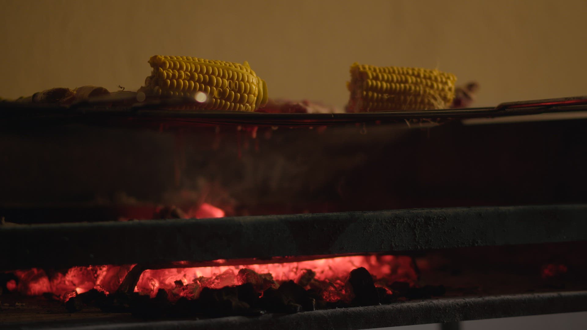 Roasting meat and corn on charcoal grill