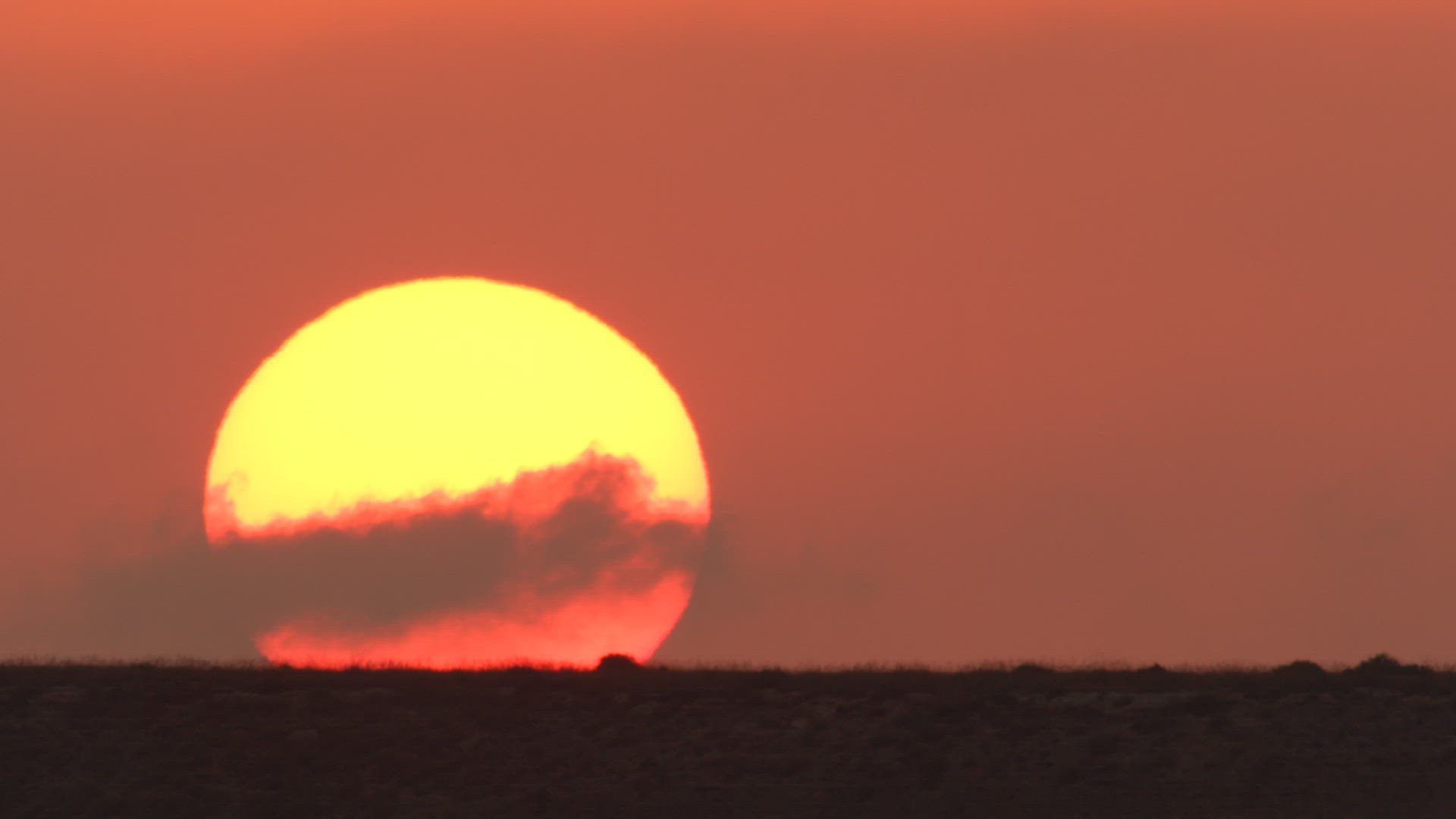 Big sun ascending in orange sky
