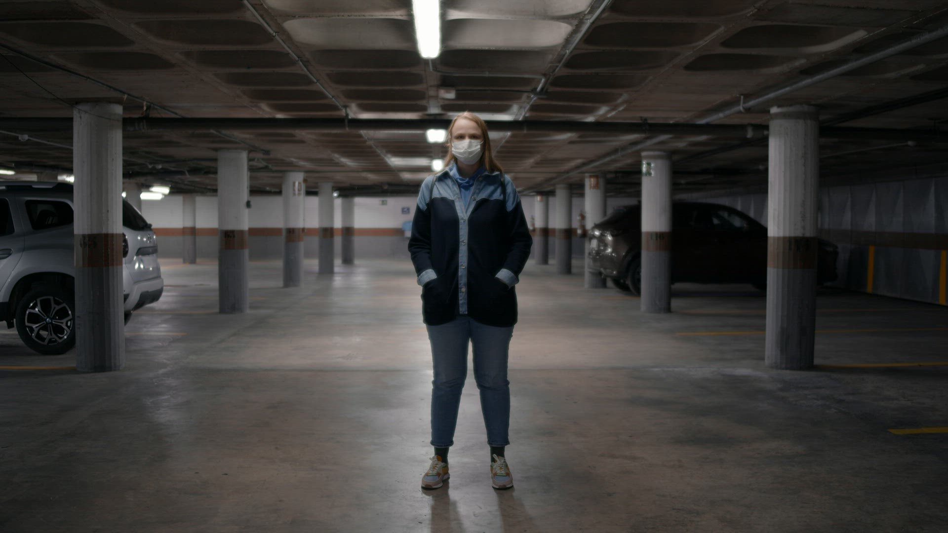 Woman in mask in underground space with blinking light