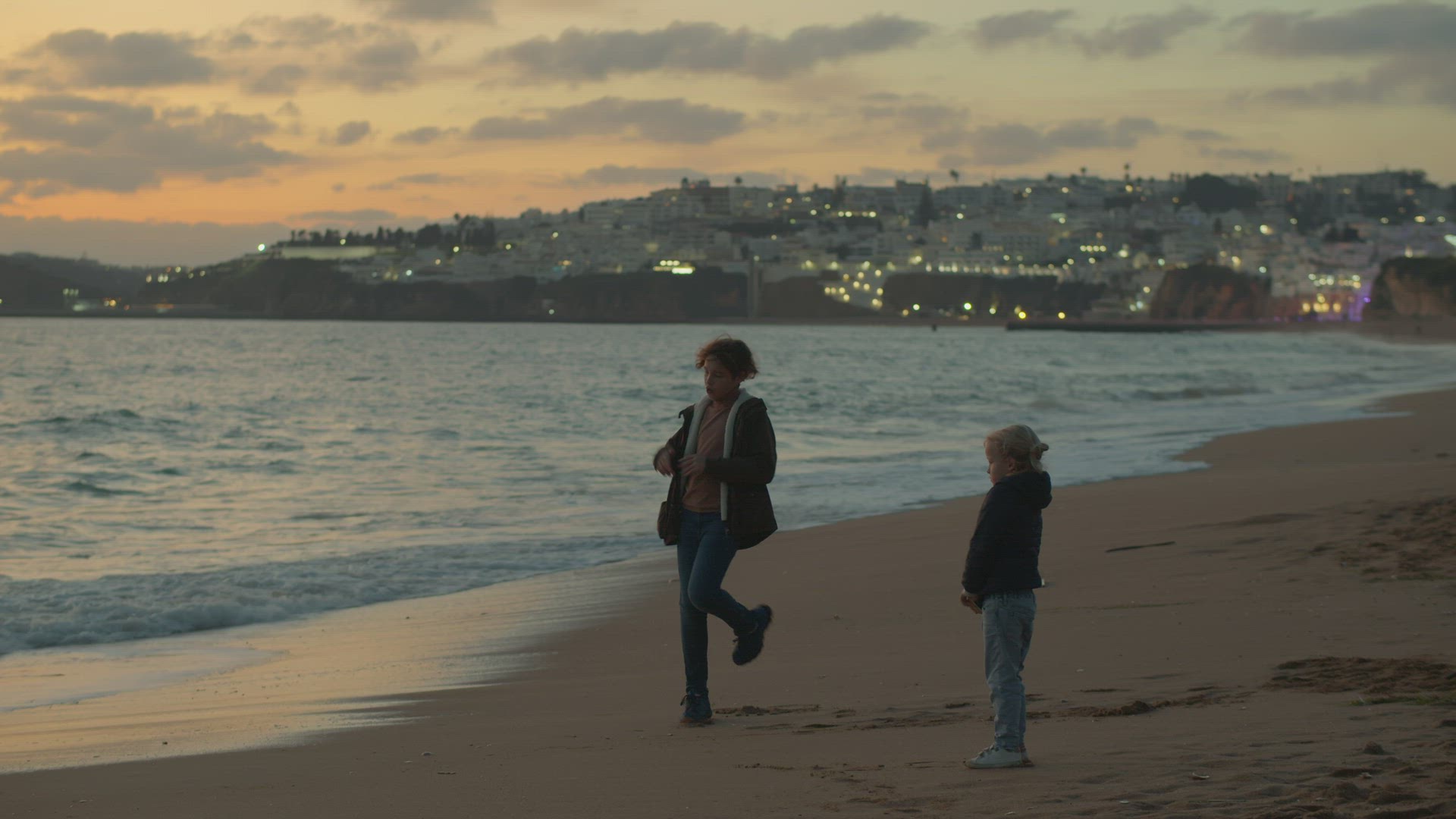 Siblings on beach, boy dancing