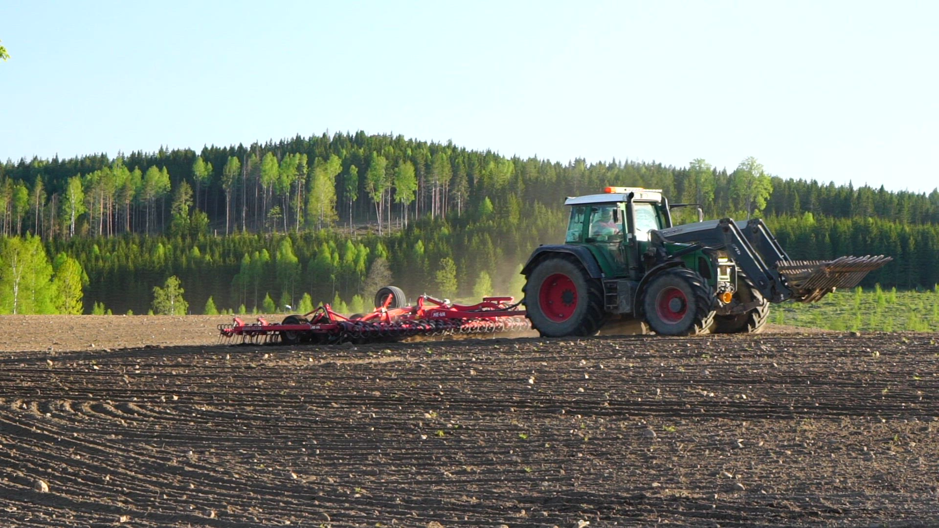 slow motion shot of farmer working in field with tractor - spring season