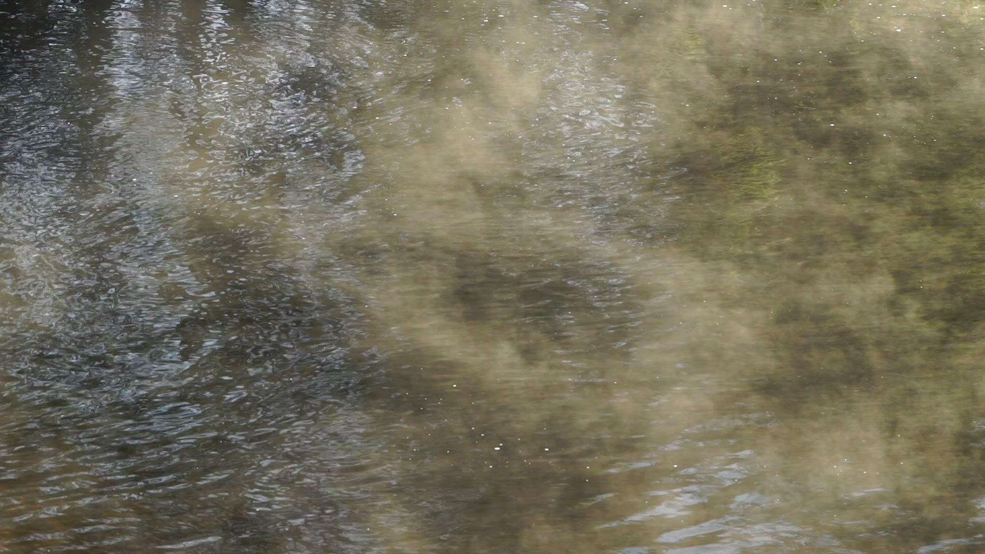 fog drifting slowly over river water - early morning shot - sun shining