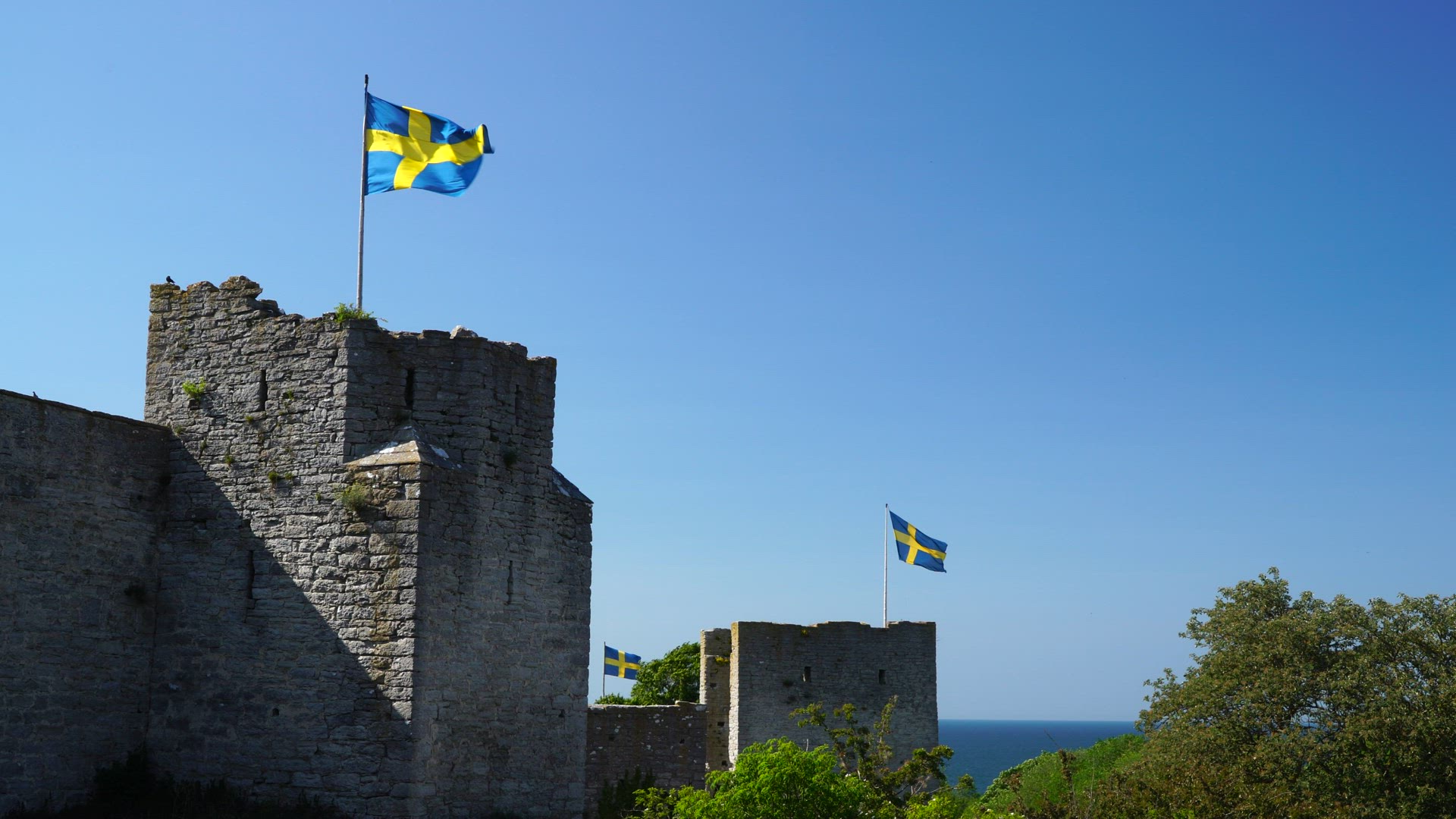 Visby City Wall - towers with three swedish flags in strong wind