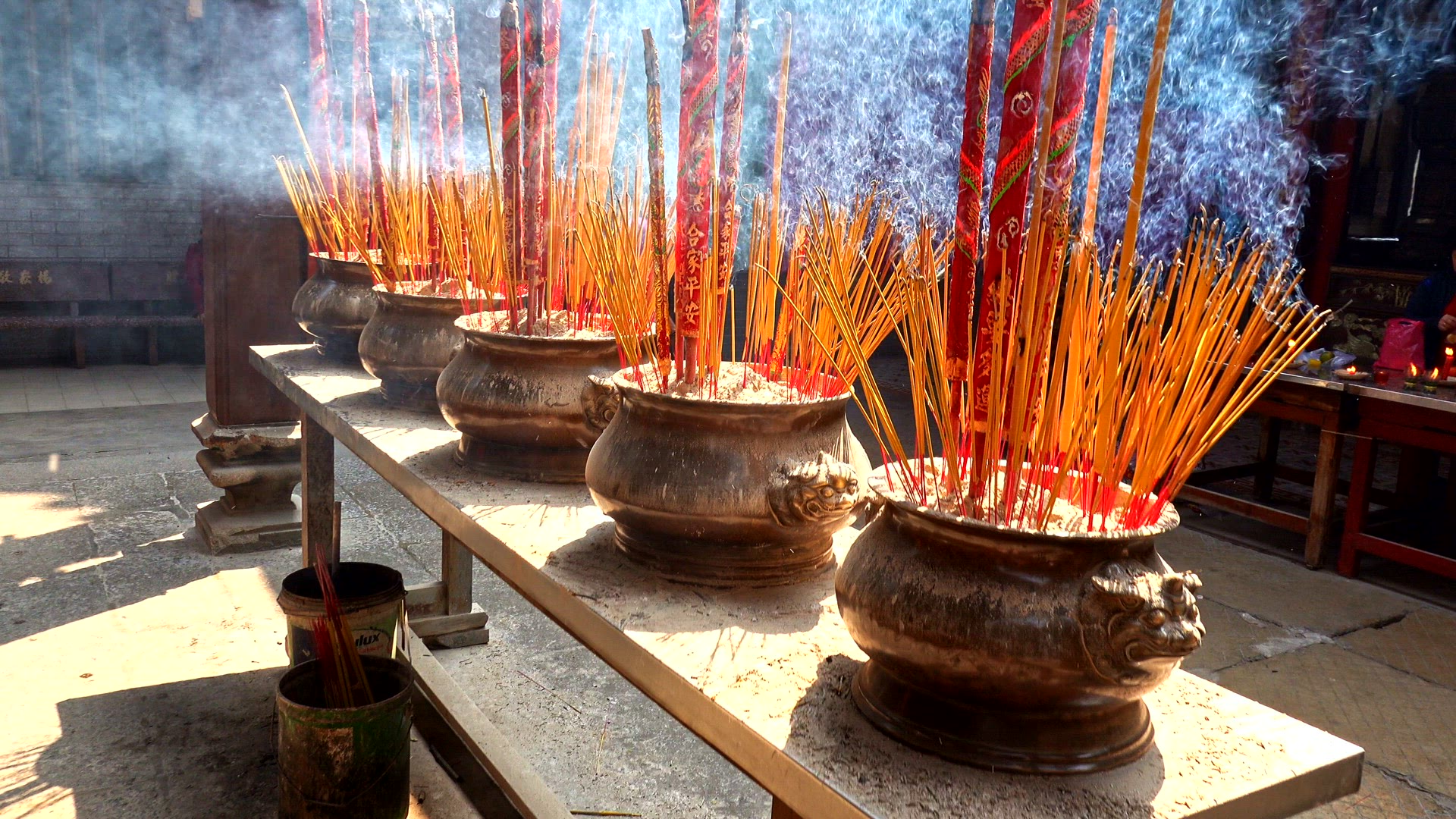 Large pots of incense burning in a temple courtyard in Vietnam