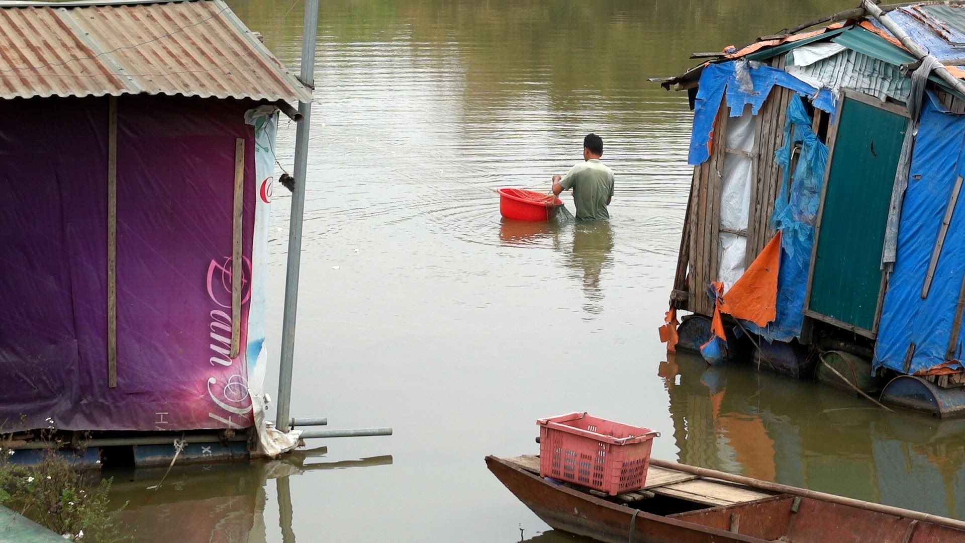 Man wading in a river setting up a fishing net