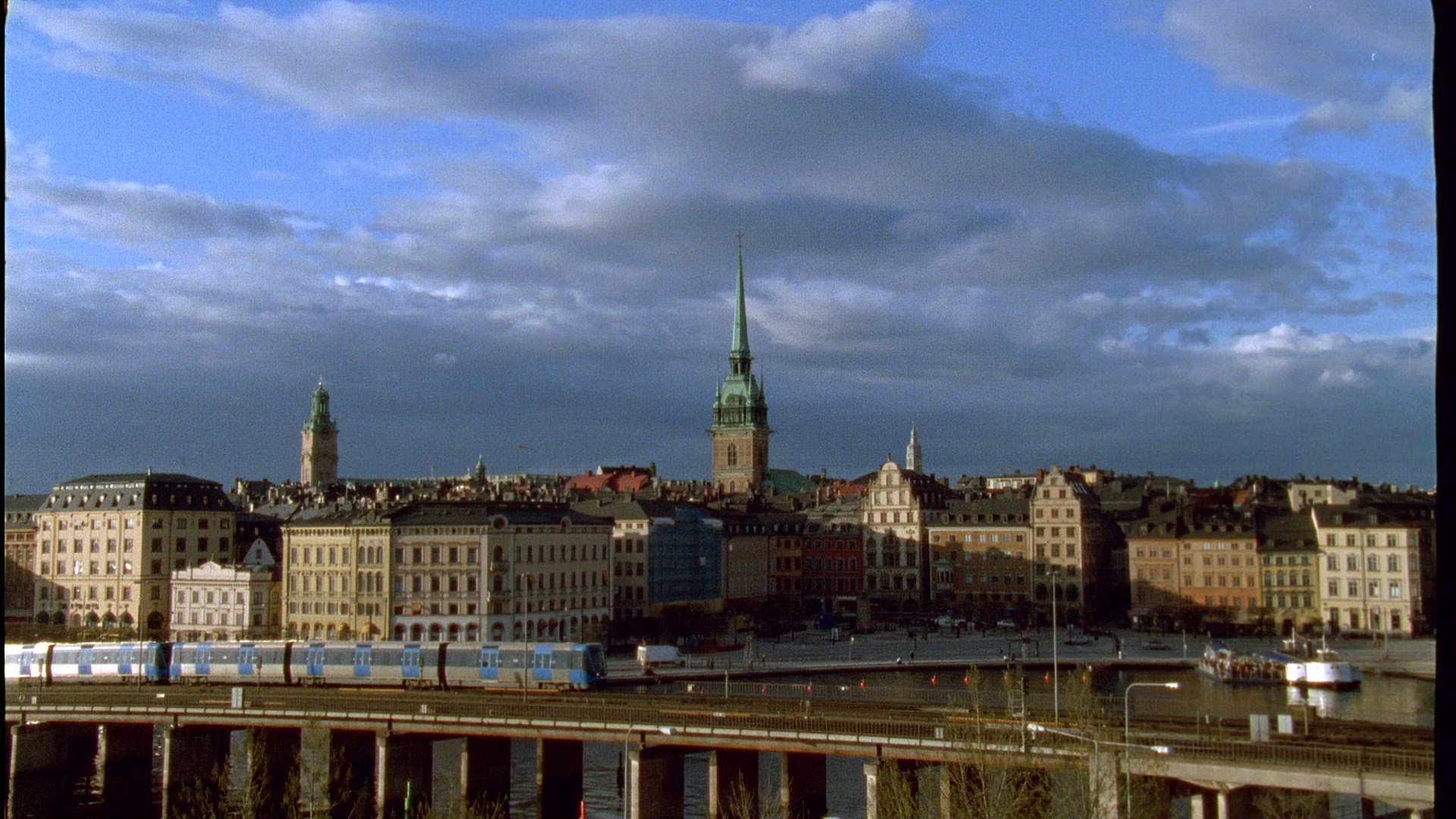 subway trains passing on bridge - gamla stan in stockholm in background - silhouette - skyline