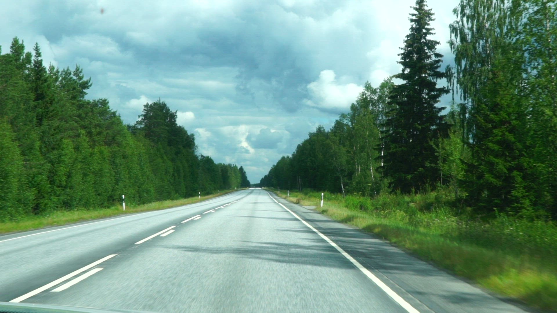 front window view from car - point of view - slow motion - driving on asphalt road in Finland