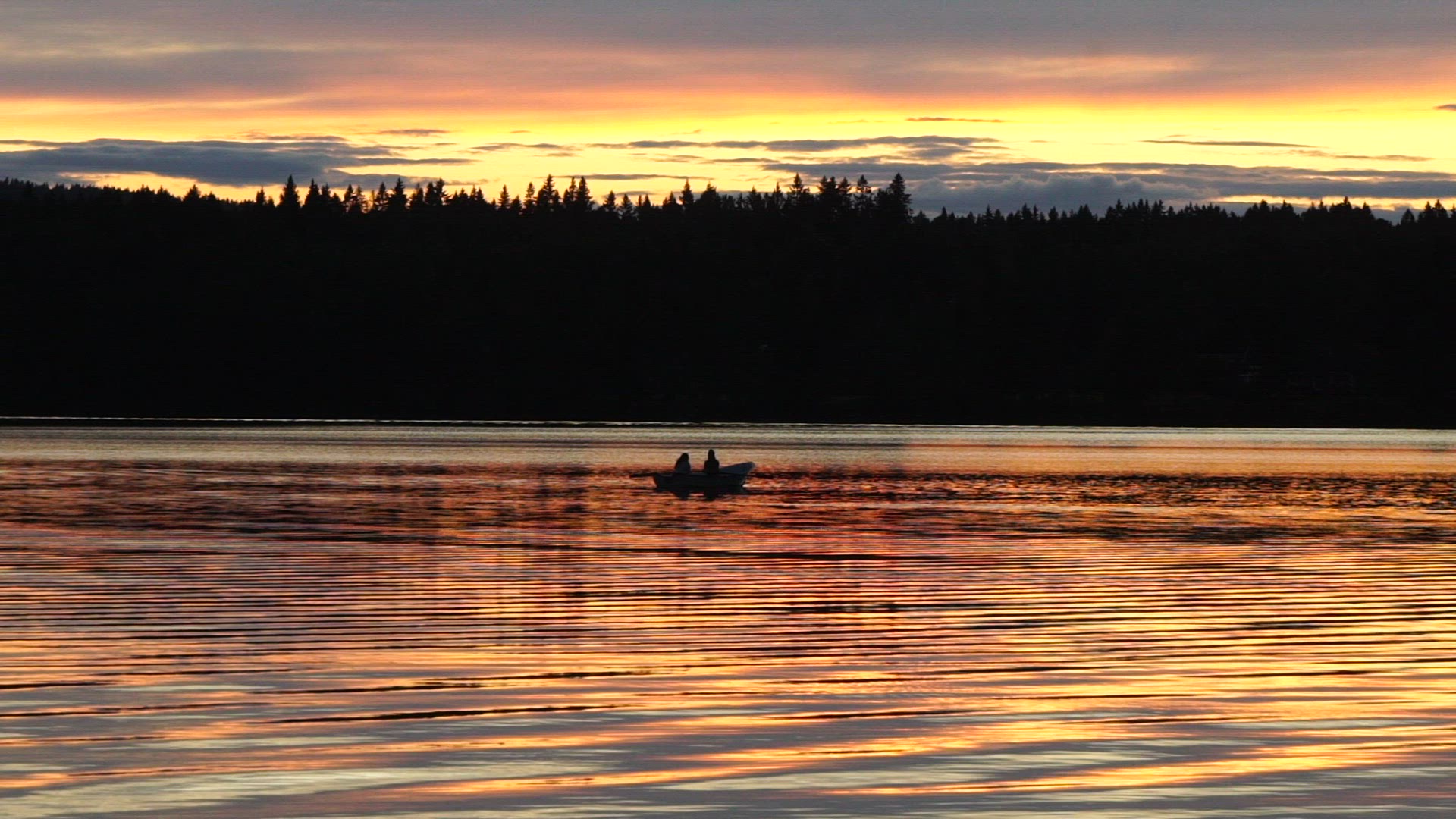 women in rowing boat on lake - twilight - dusk - golden house - magic hour