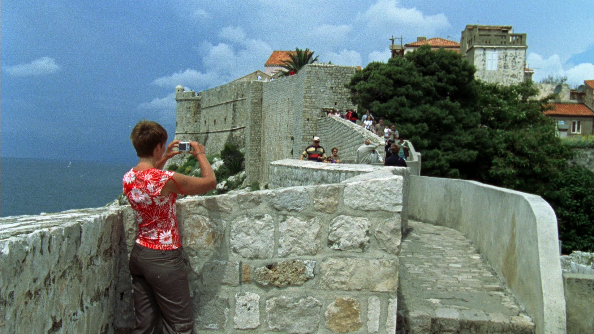 woman taking pictures at city wall in Dubrovnik in Croatia - tourists - old fashined camera