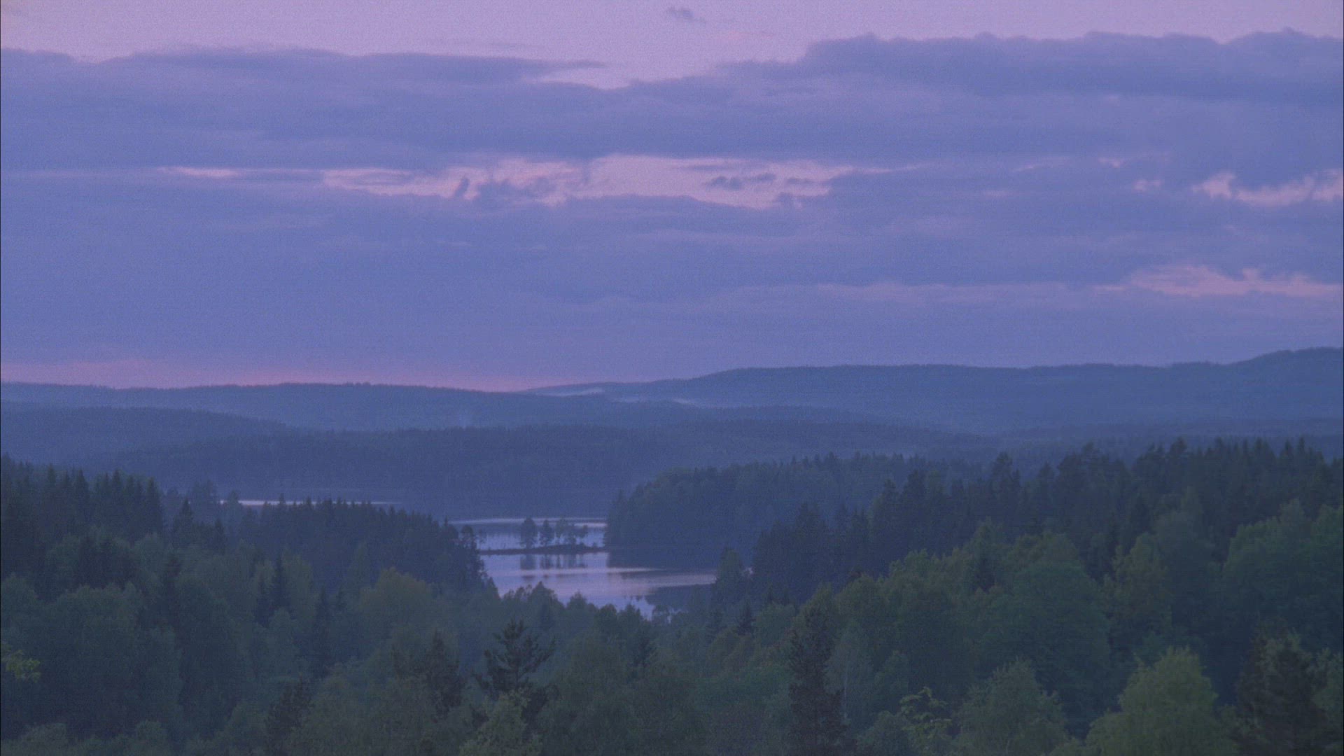 timelapse shot with view over misty forests and lake in Värmland - clouds moving