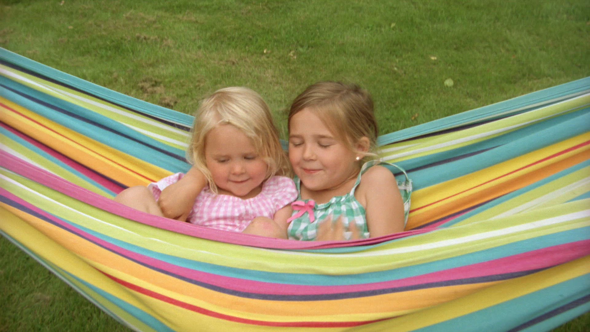young girls relaxing and playing in colourful hammock