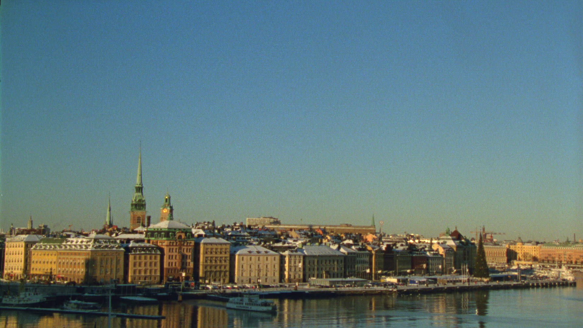 view over old town in stockholm - small ferry leaving - wintry weather - snow - cold