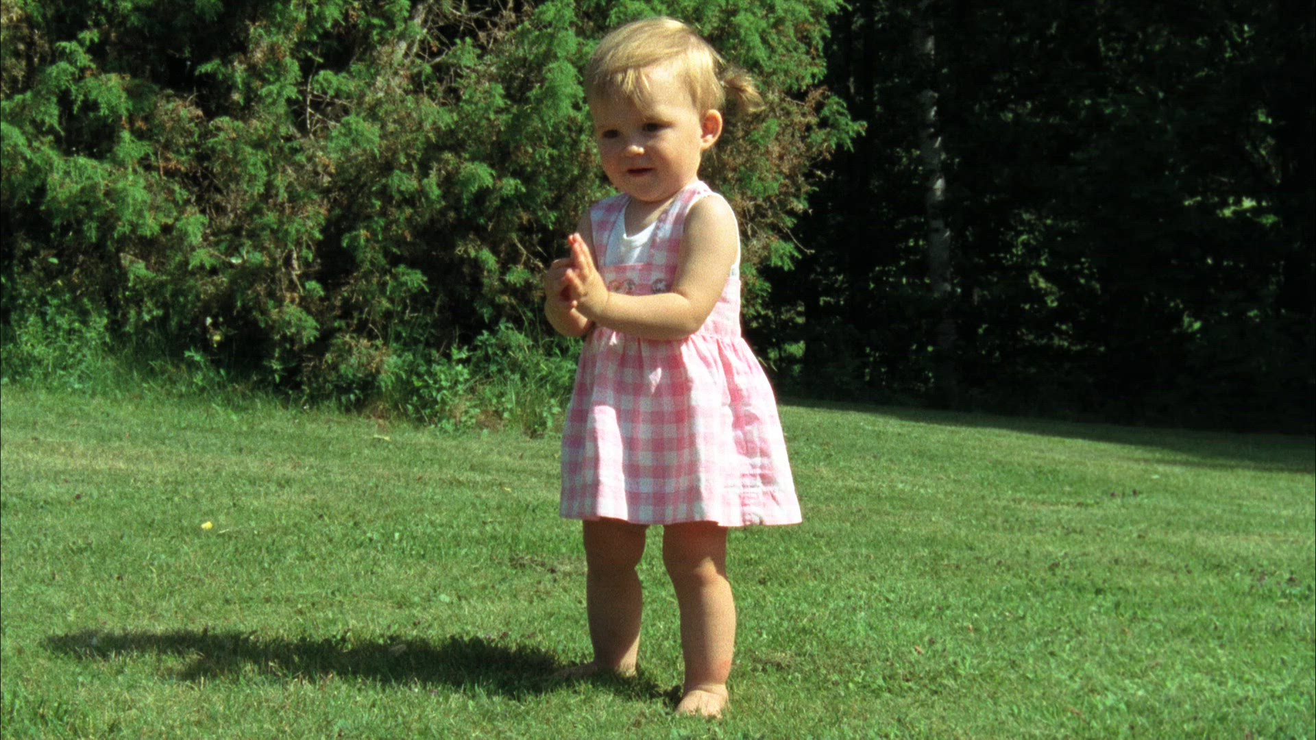 young girl standing on lawn  - clapping hands and dancing
