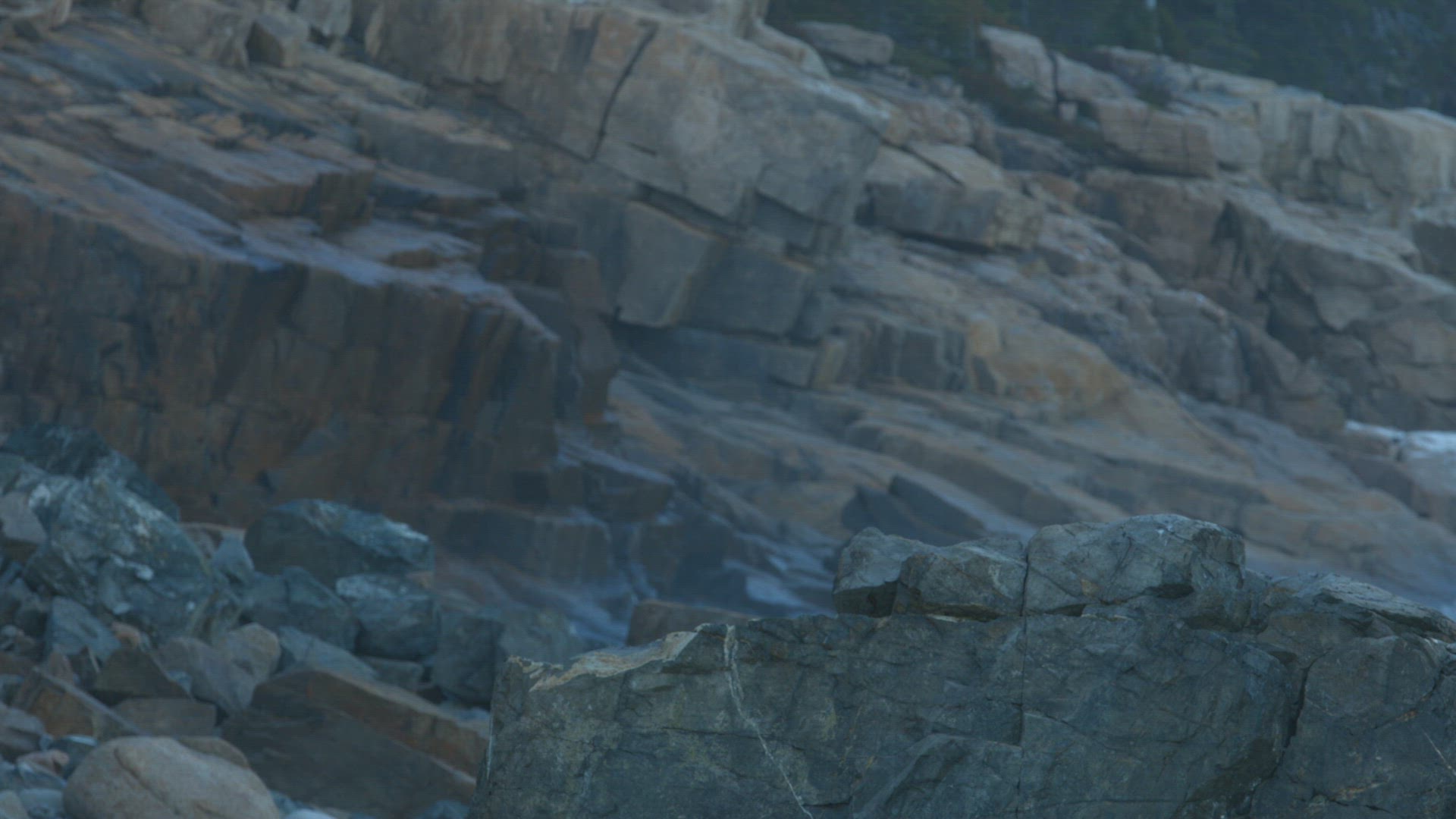 Wave crashing on black rocks