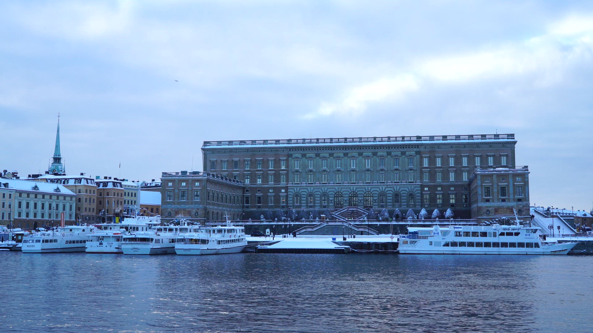 view water white boats at quay and royal palace in stockholm - wintertime - wintry shot