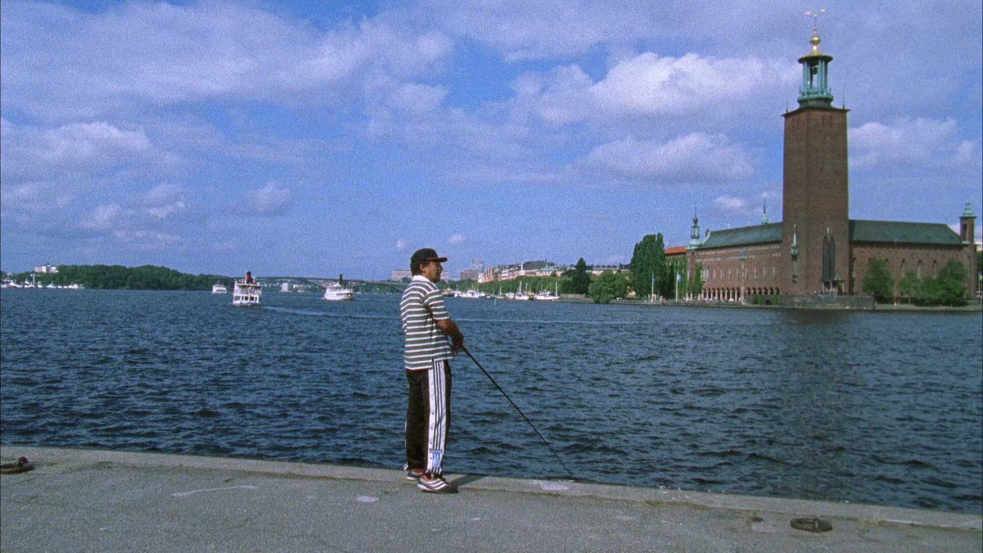 men fishing in central Stockholm - catching perch - casting rod - city hall in background