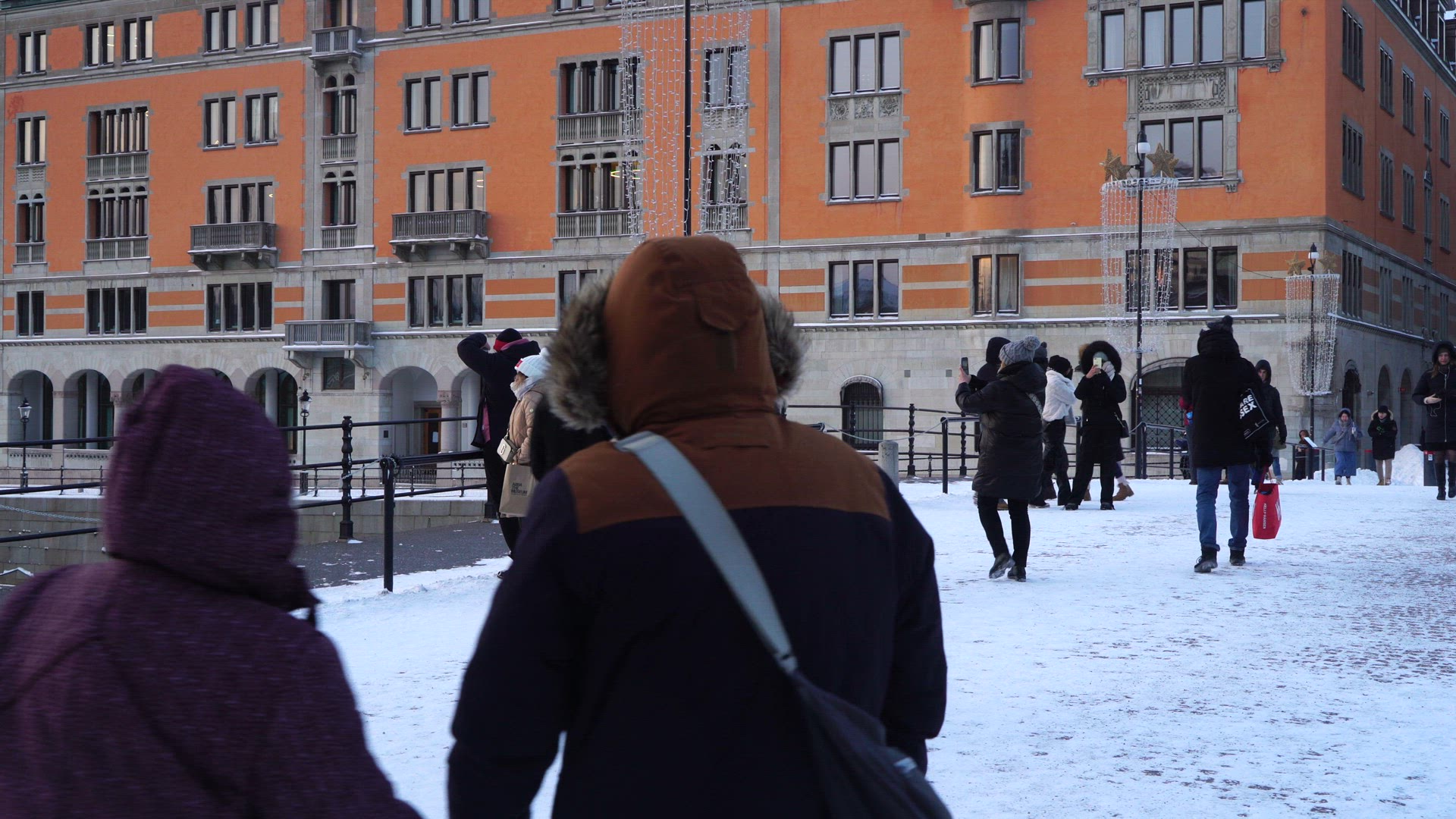 riksbron in central stockholm - people dressed in winter clothes - cold weather - tourists 
