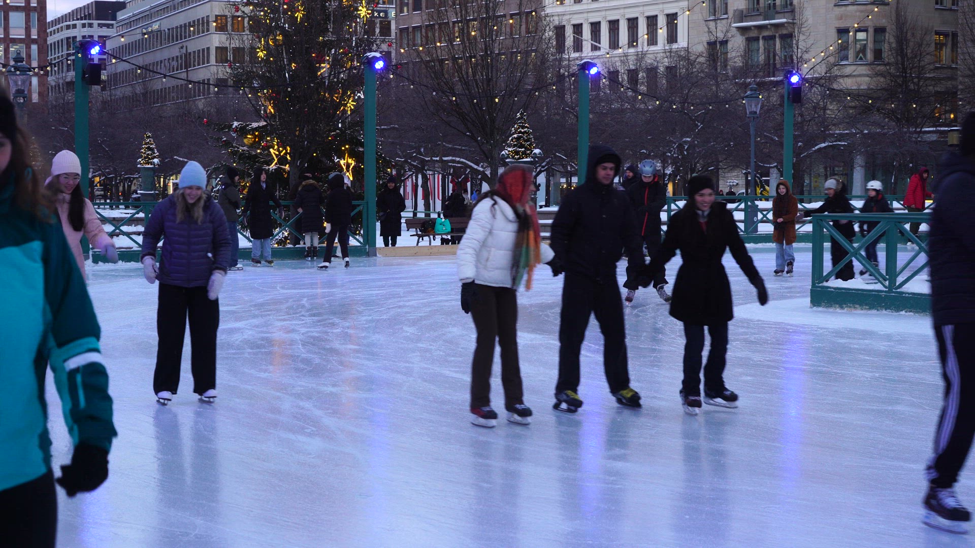 people skating on ice rink in Kungsträdgården in central stockholm - slow motion - crowd of people