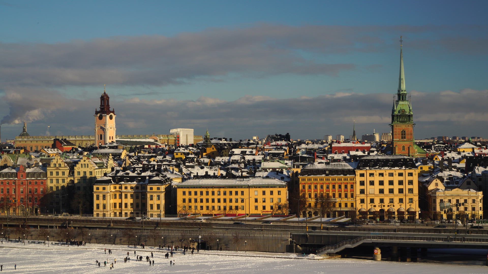 view over wintry stockholm - old town - people walking on ice in central stockholm
