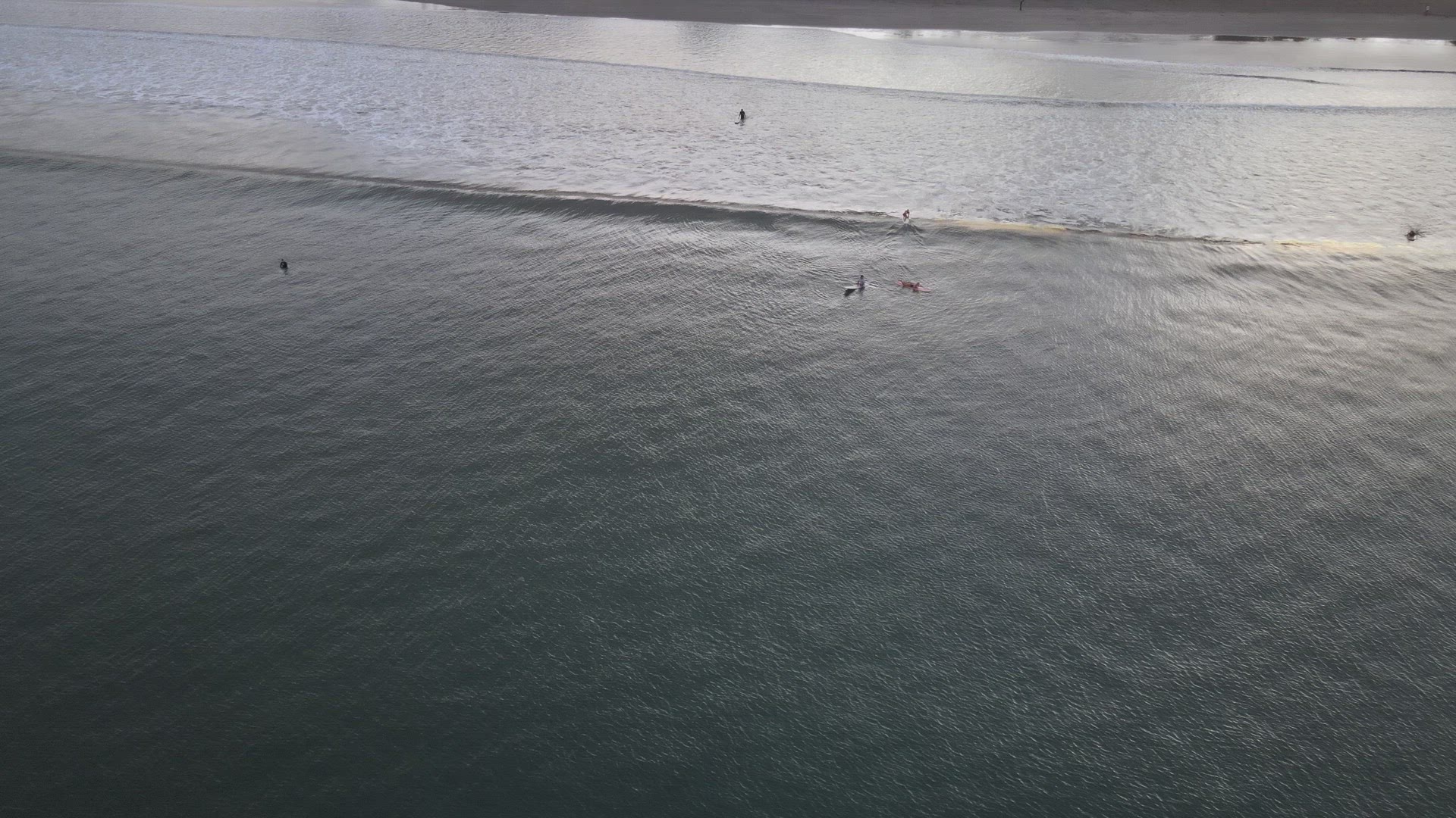 Surfers Catching Waves at Sunrise