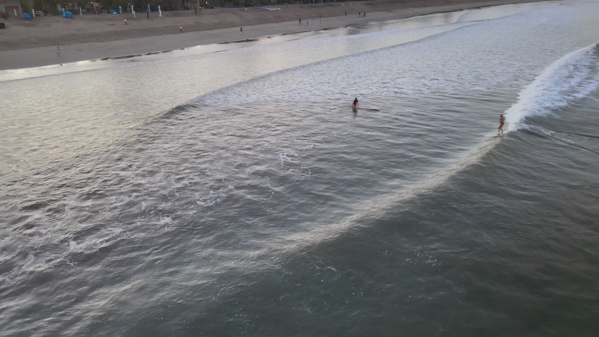 Surfers Catching Waves at Sunrise