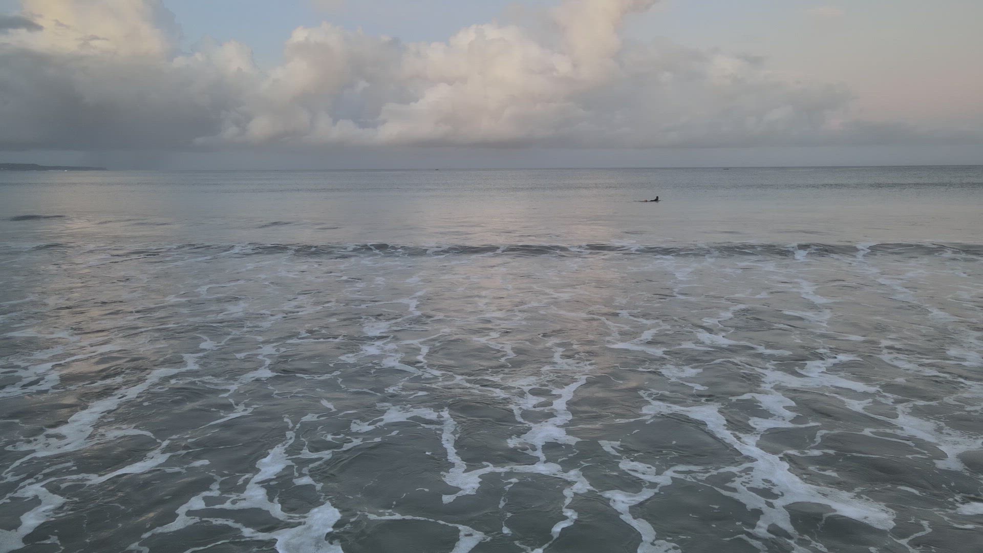 Surfers Catching Waves at Sunrise