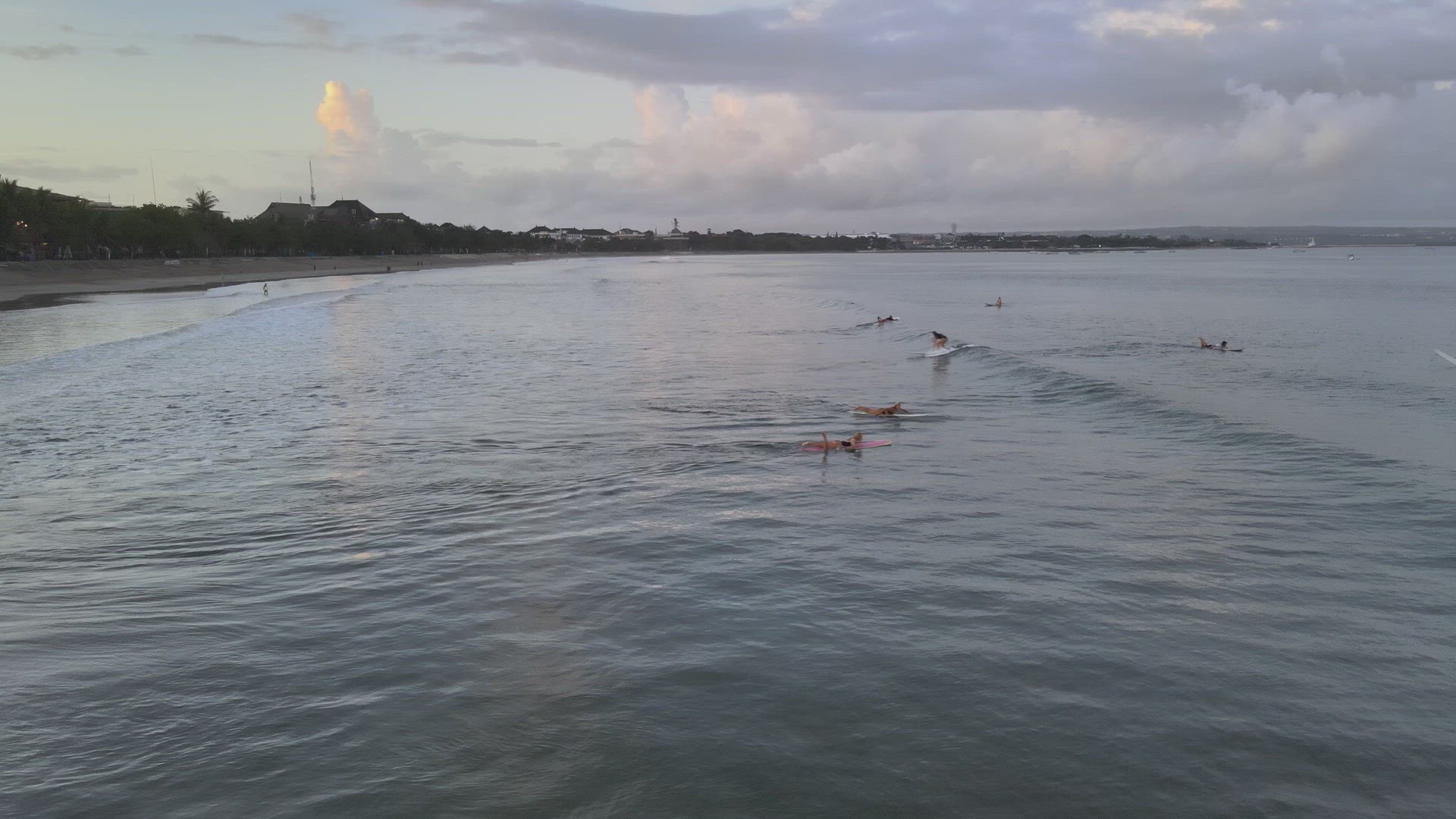 Surfers Catching Waves at Sunrise