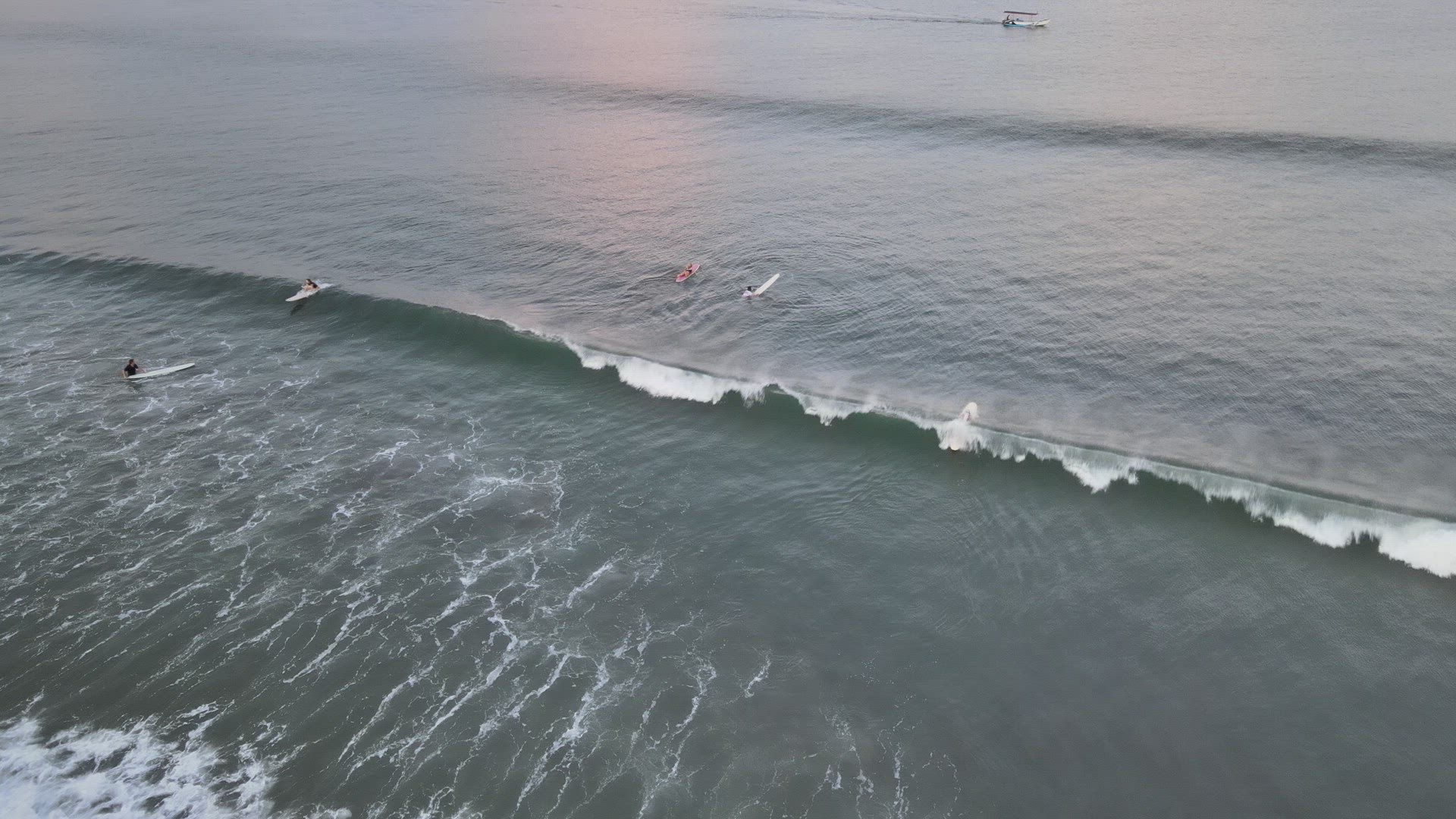 Surfers Catching Waves at Sunrise
