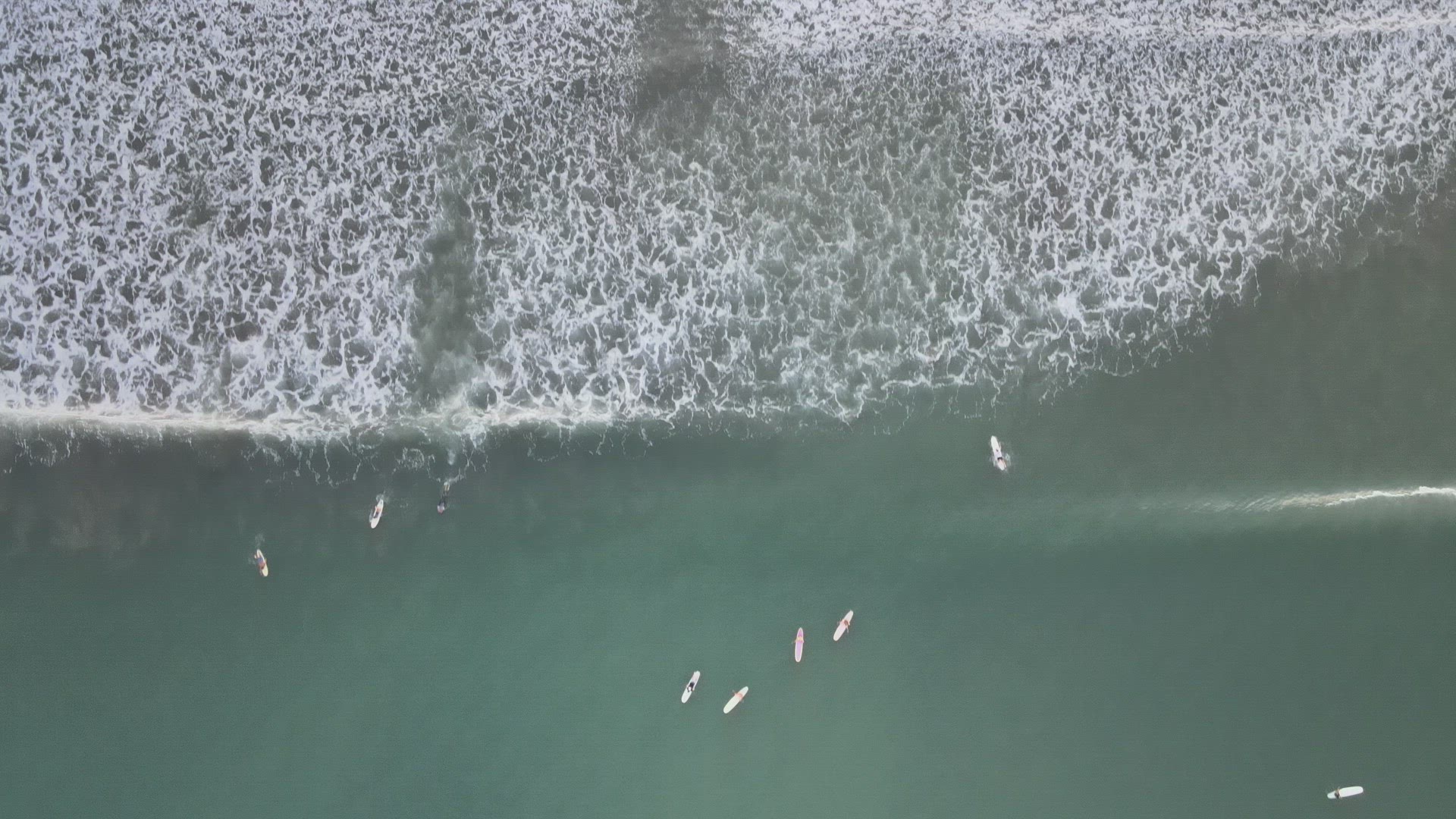 Surfers Catching Waves at Sunrise
