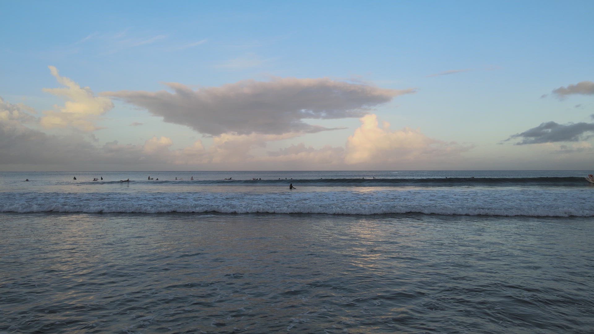 Surfers Catching Waves at Sunrise
