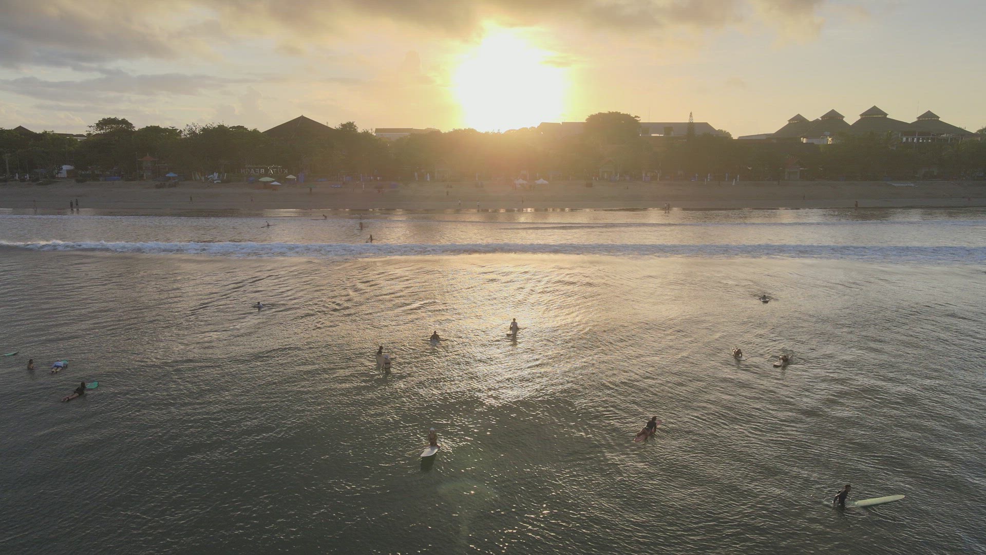 Surfers Catching Waves at Sunrise