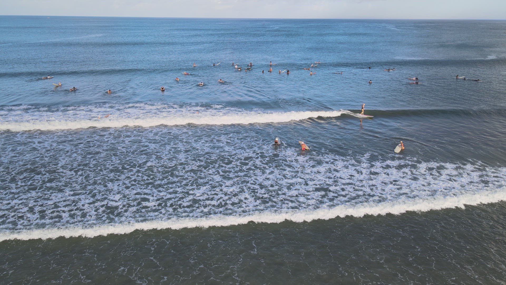 Surfers Catching Waves at Sunrise