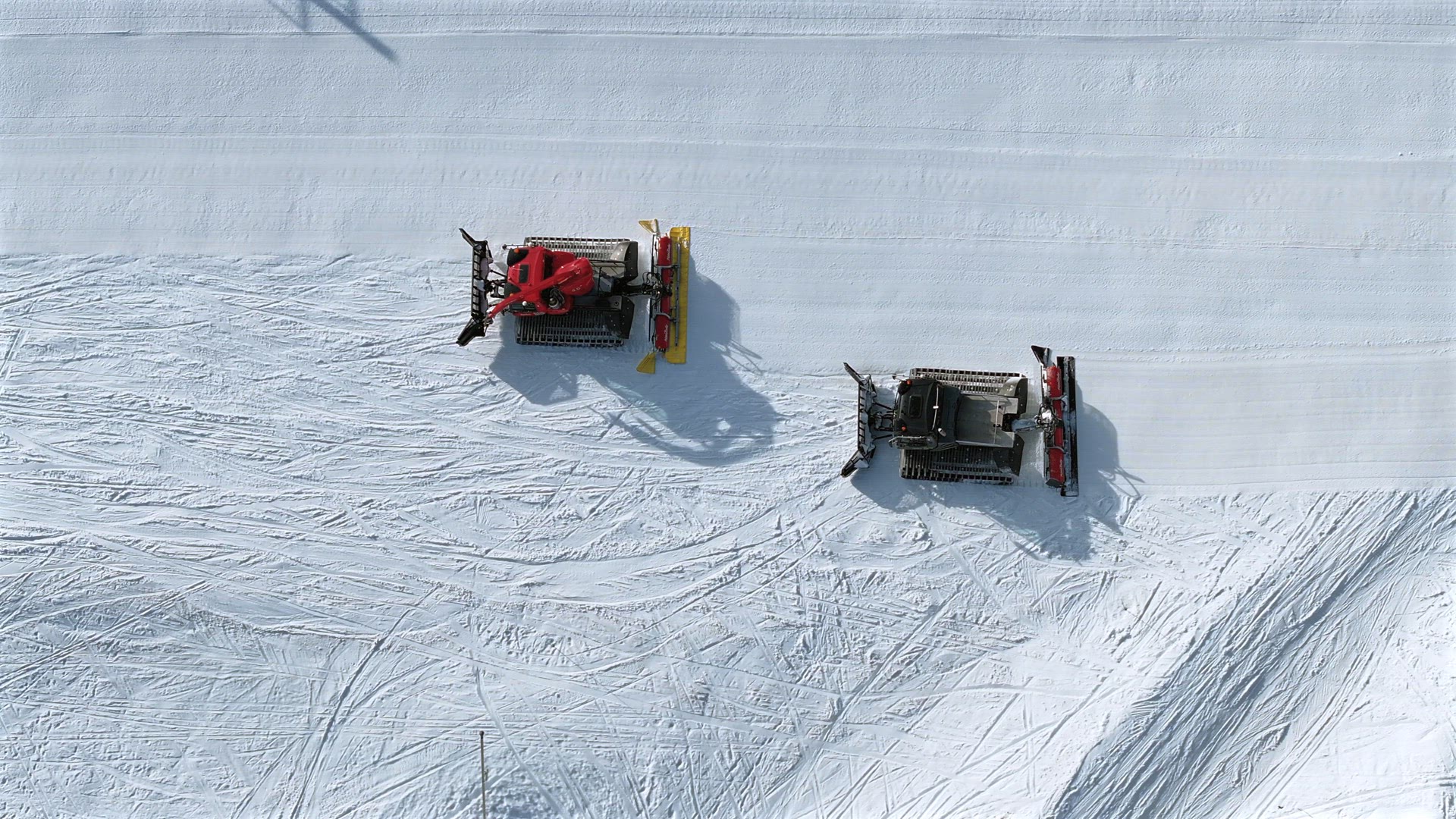 Snow Groomer and Piste Basher Working on a Ski Piste Aerial View