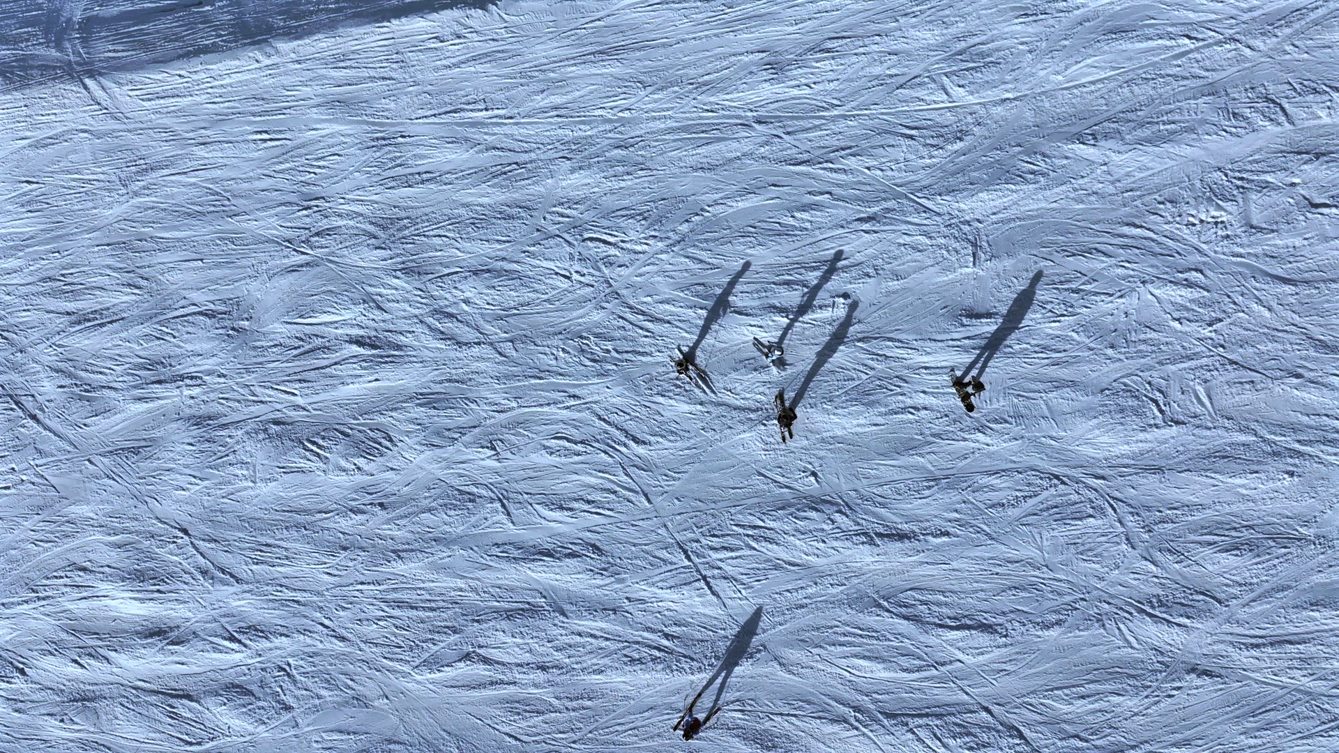 Abstract Aerial View of Skiers on a Slope With Shadows