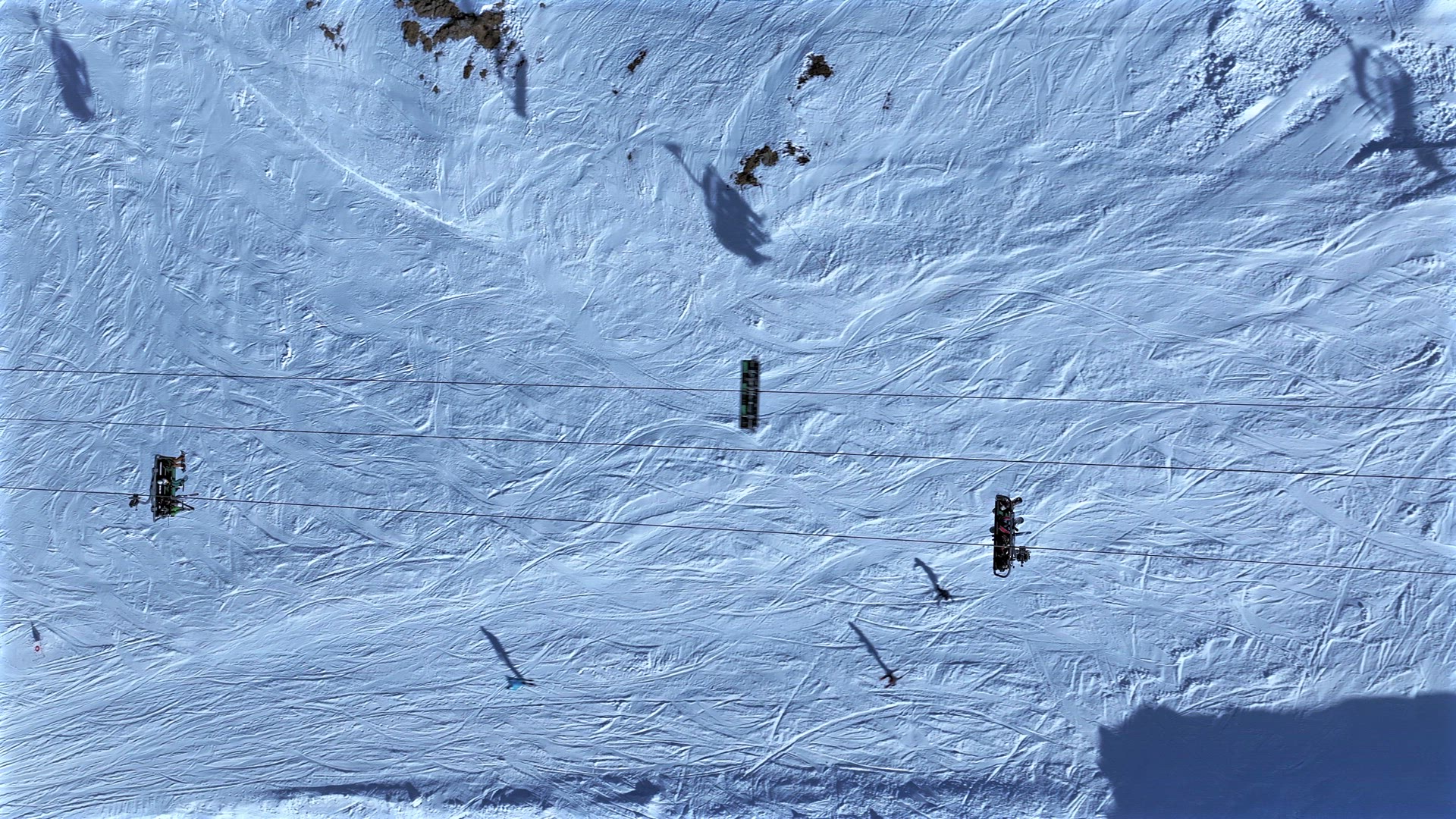 Skiers and Snowboarders Using a Chairlift To Ascend a Mountain